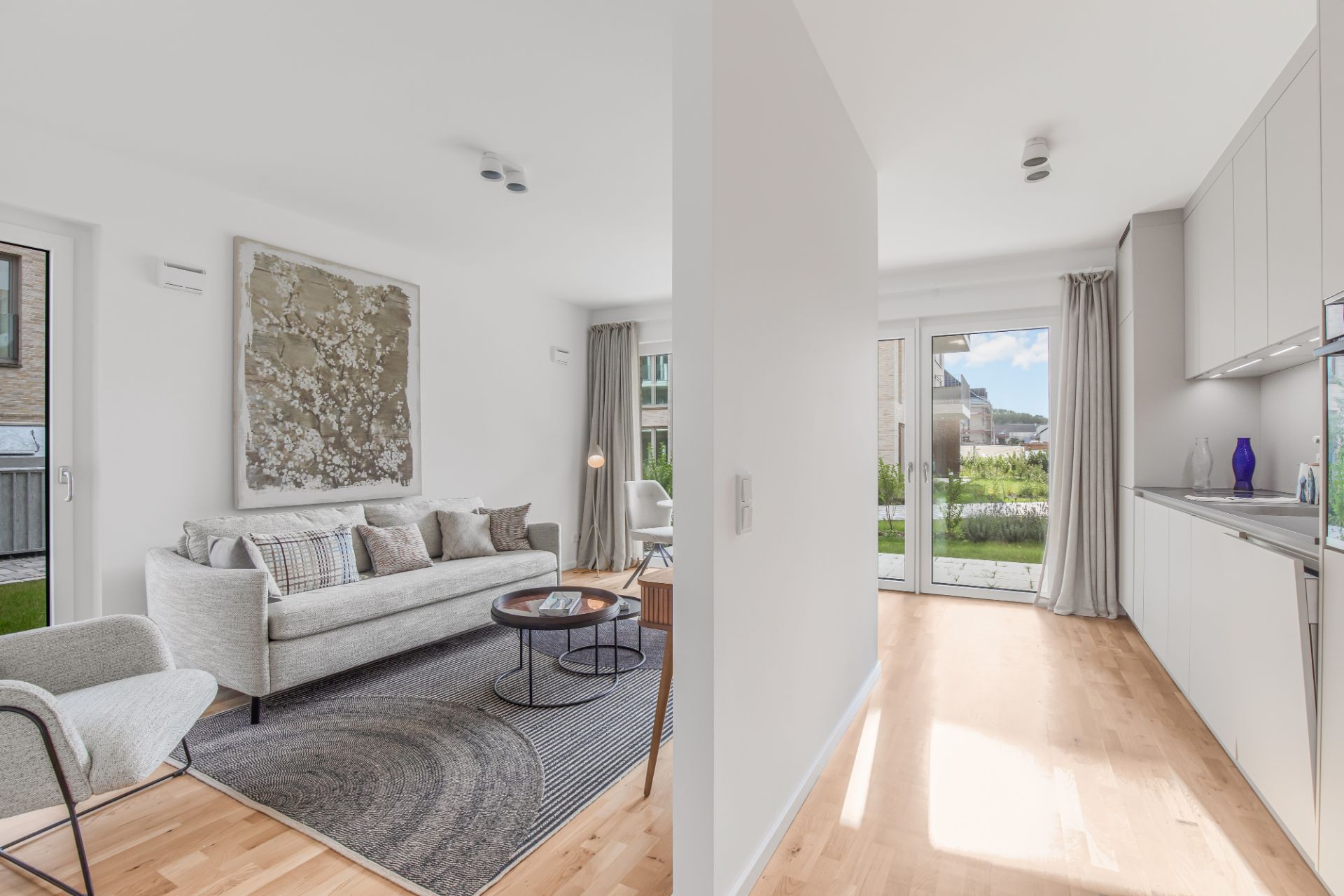 Helles Wohnzimmer mit Sofa und Sessel, daneben offene Küche mit großen Fenstern zum Garten.