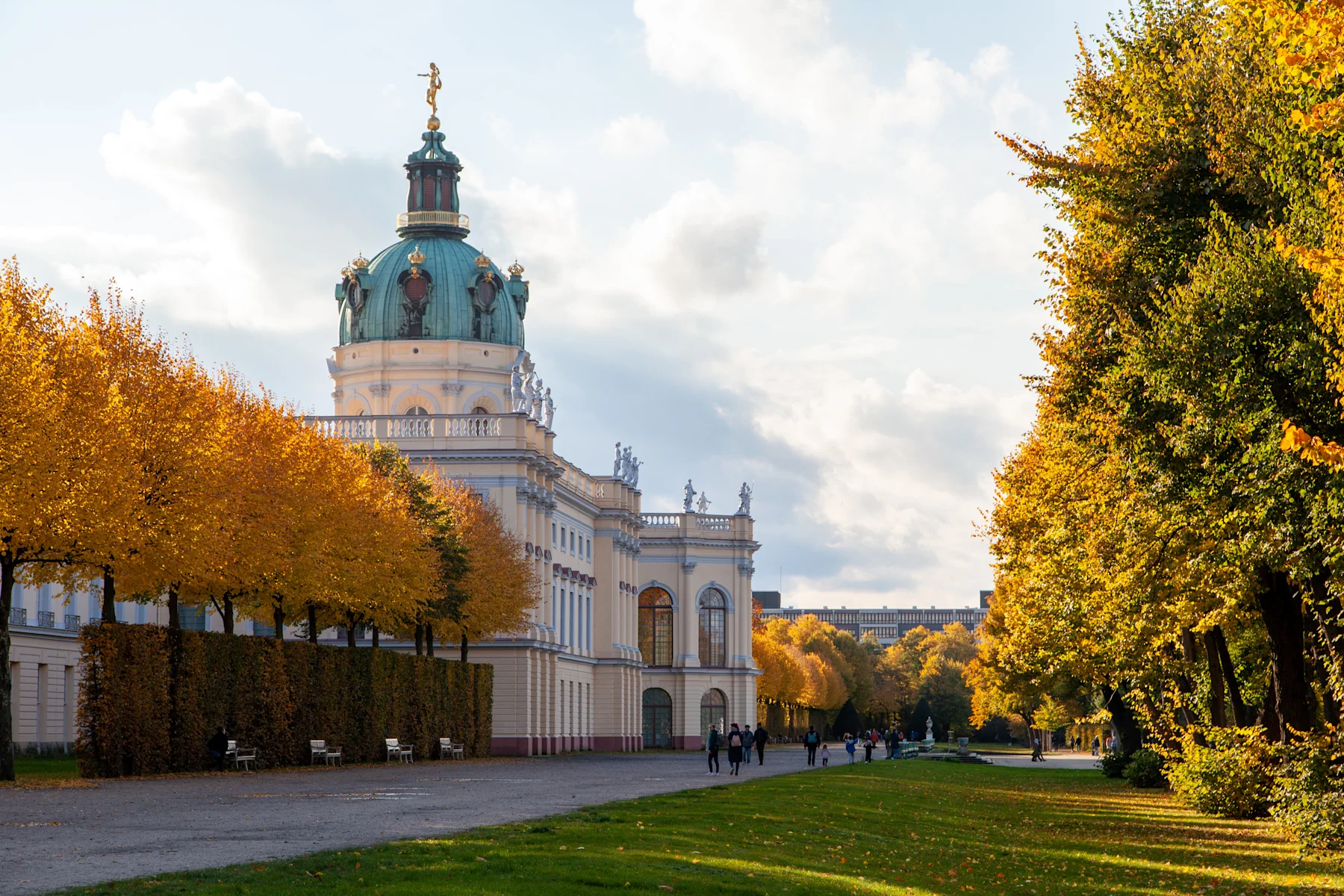 Stadtansicht mit modernen Hochhäusern und einer historischen Kirche im Vordergrund bei Sonnenuntergang.