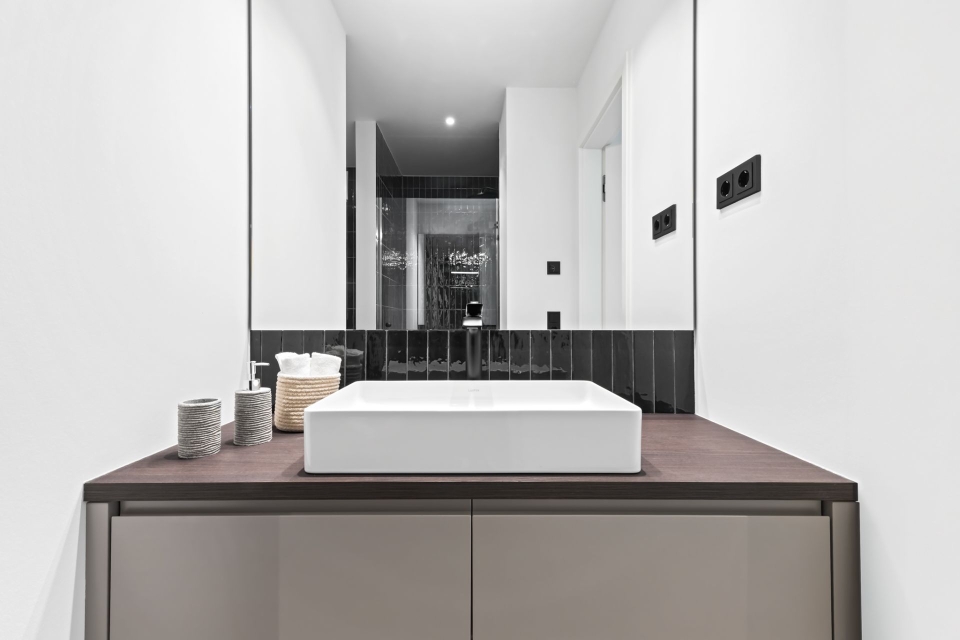 Modernes Badezimmer mit quadratischem Waschbecken und großem Spiegel.