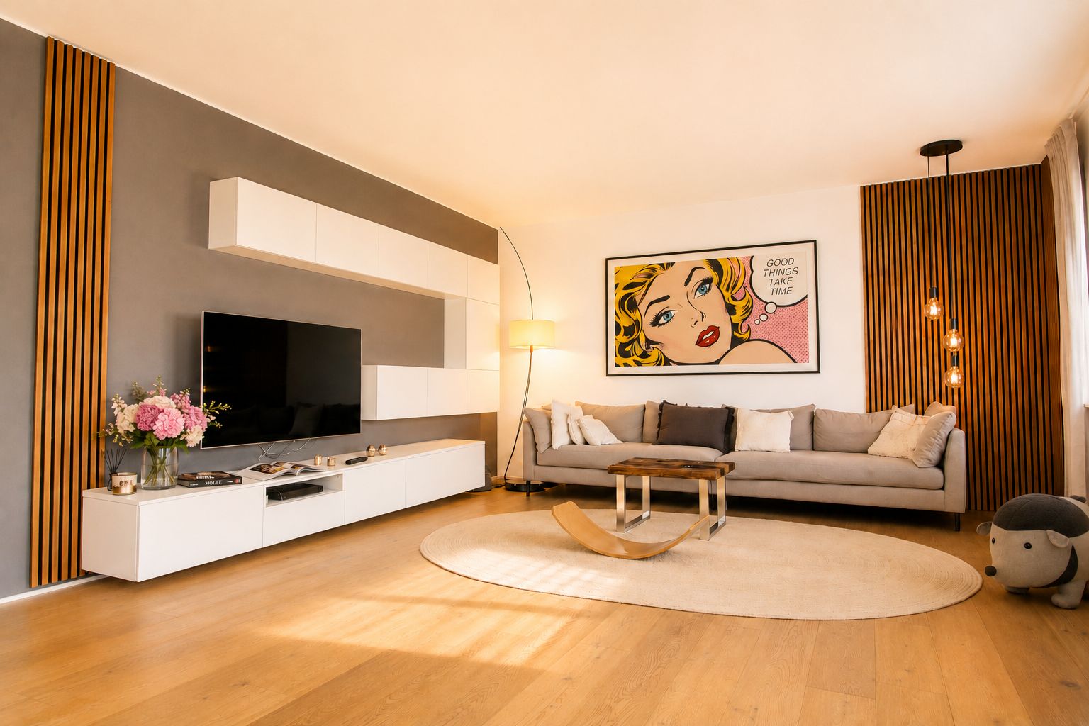 Modernes Wohnzimmer mit grauem Sofa, Fernseher, Blumen und großem Pop-Art-Bild an der Wand.