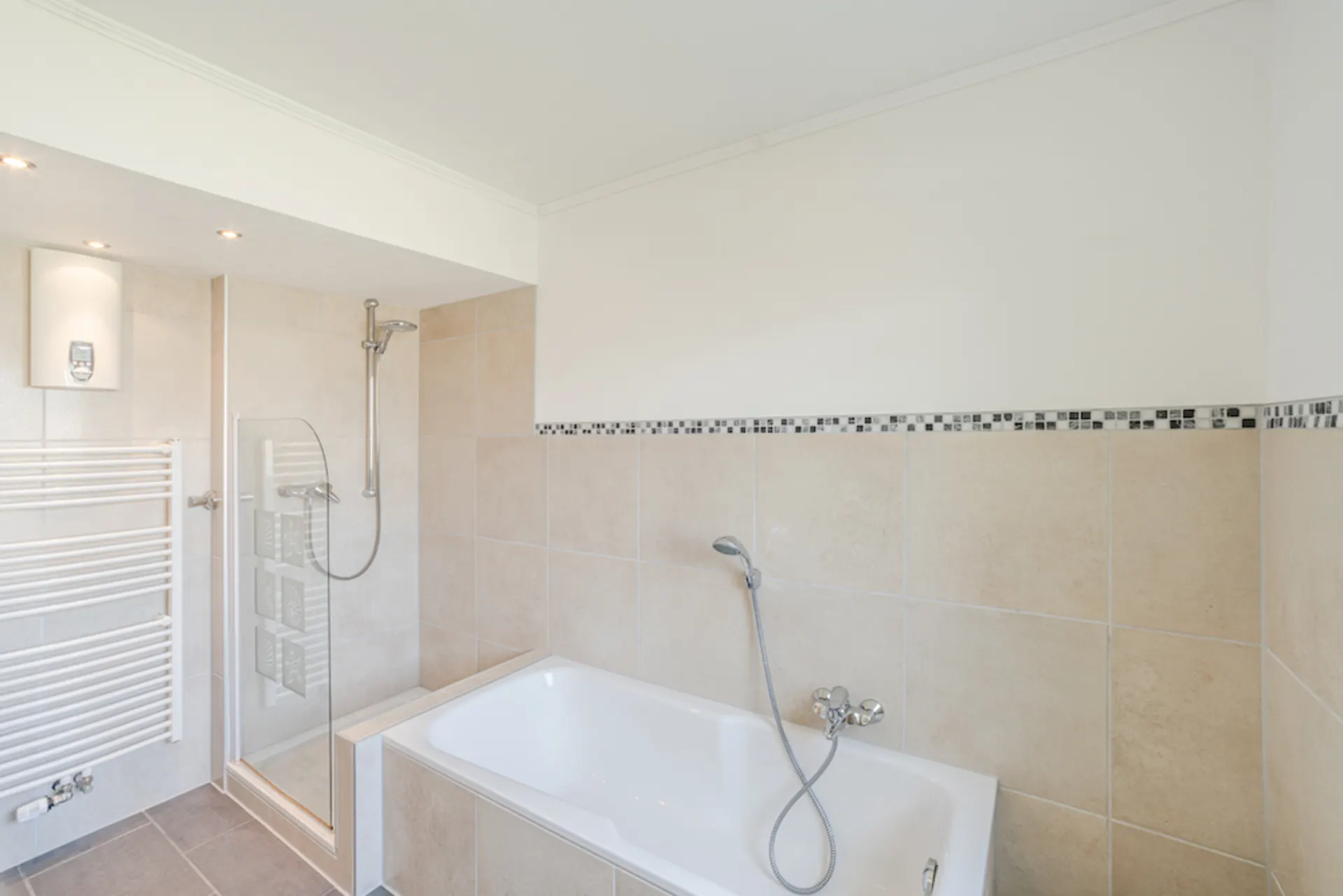 Modernes Badezimmer mit Badewanne, Dusche und Handtuchheizkörper.