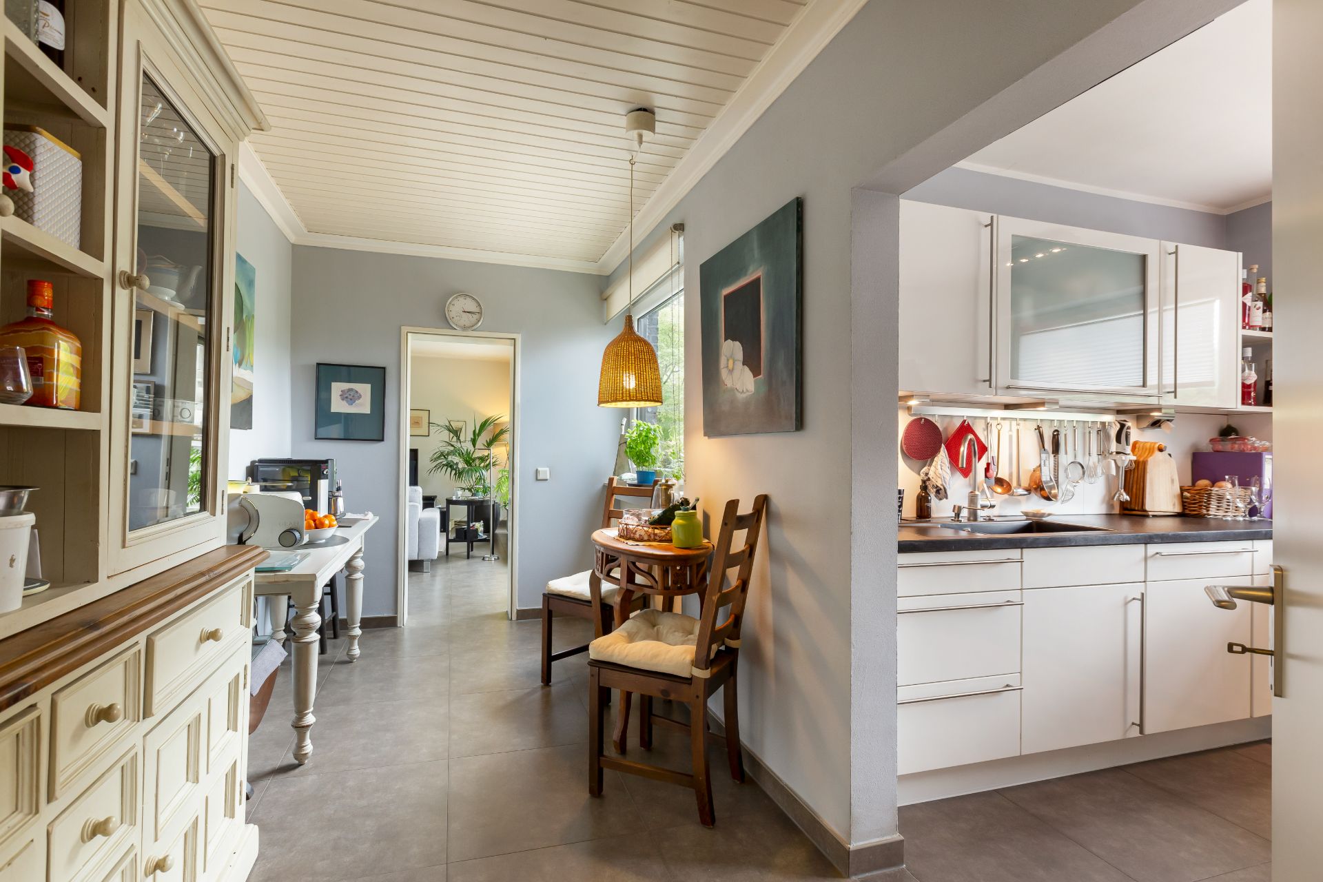 Helle Küche mit Esstisch, Stühlen und Blick ins Wohnzimmer einer Wohnung.