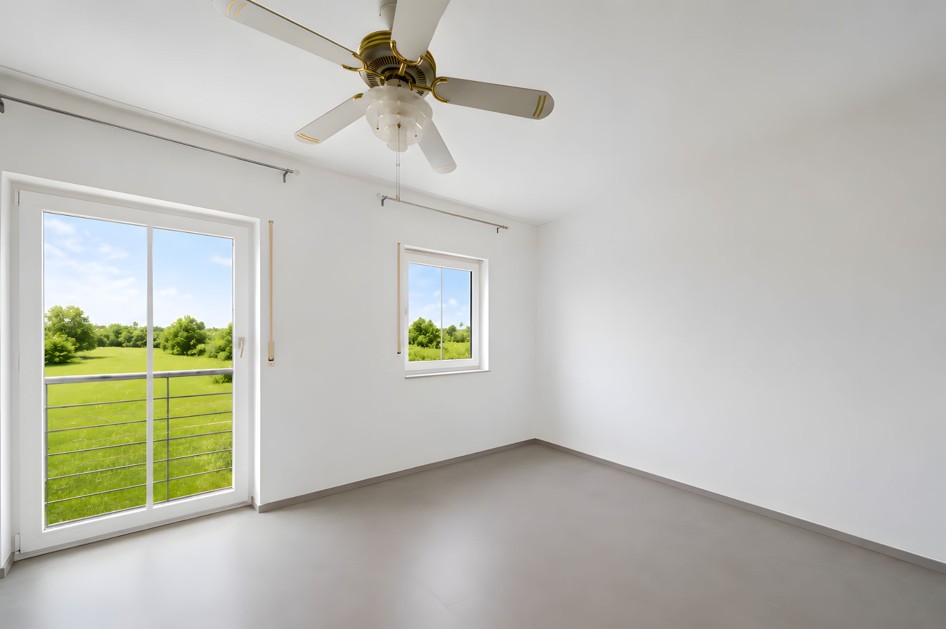 Leerer Raum mit Deckenventilator, Fenster und Tür mit Blick ins Grüne.