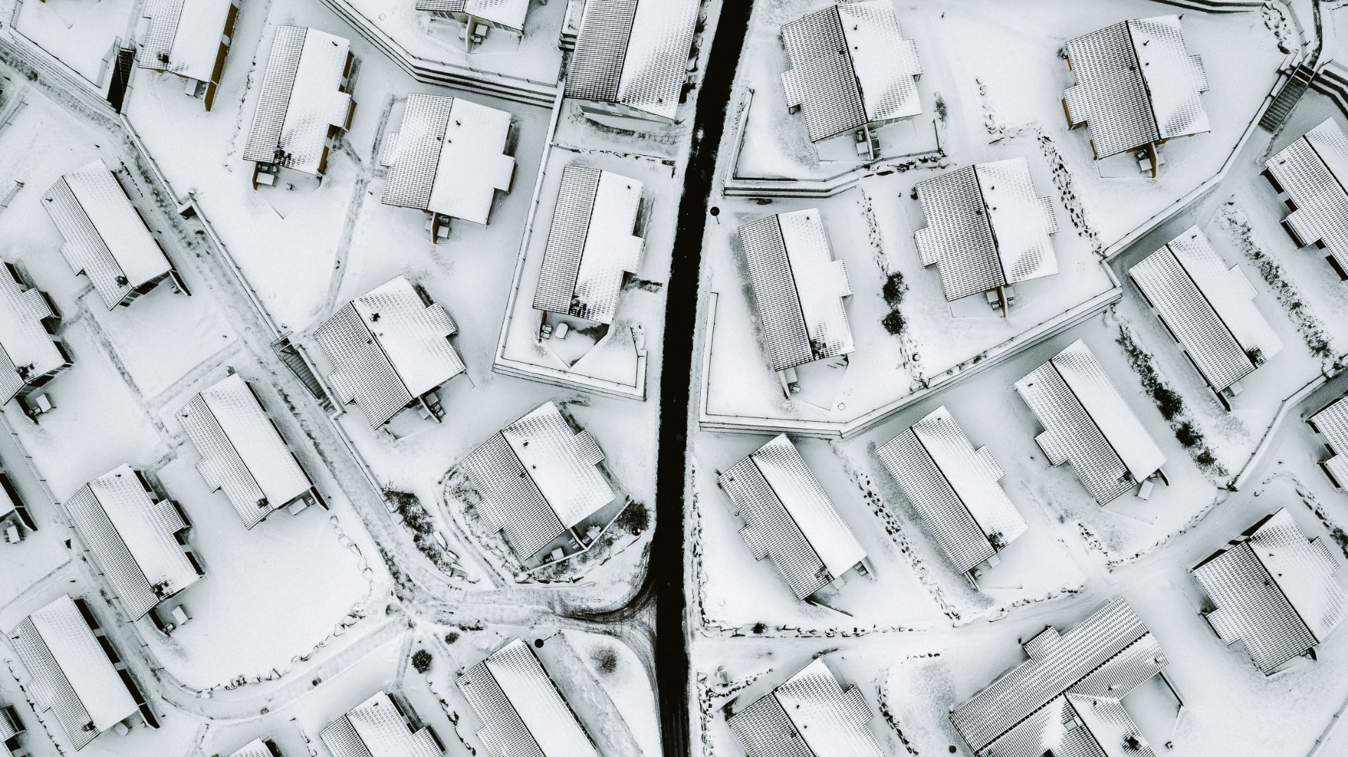 Luftaufnahme von Häusern und Straßen, alles ist mit Schnee bedeckt.