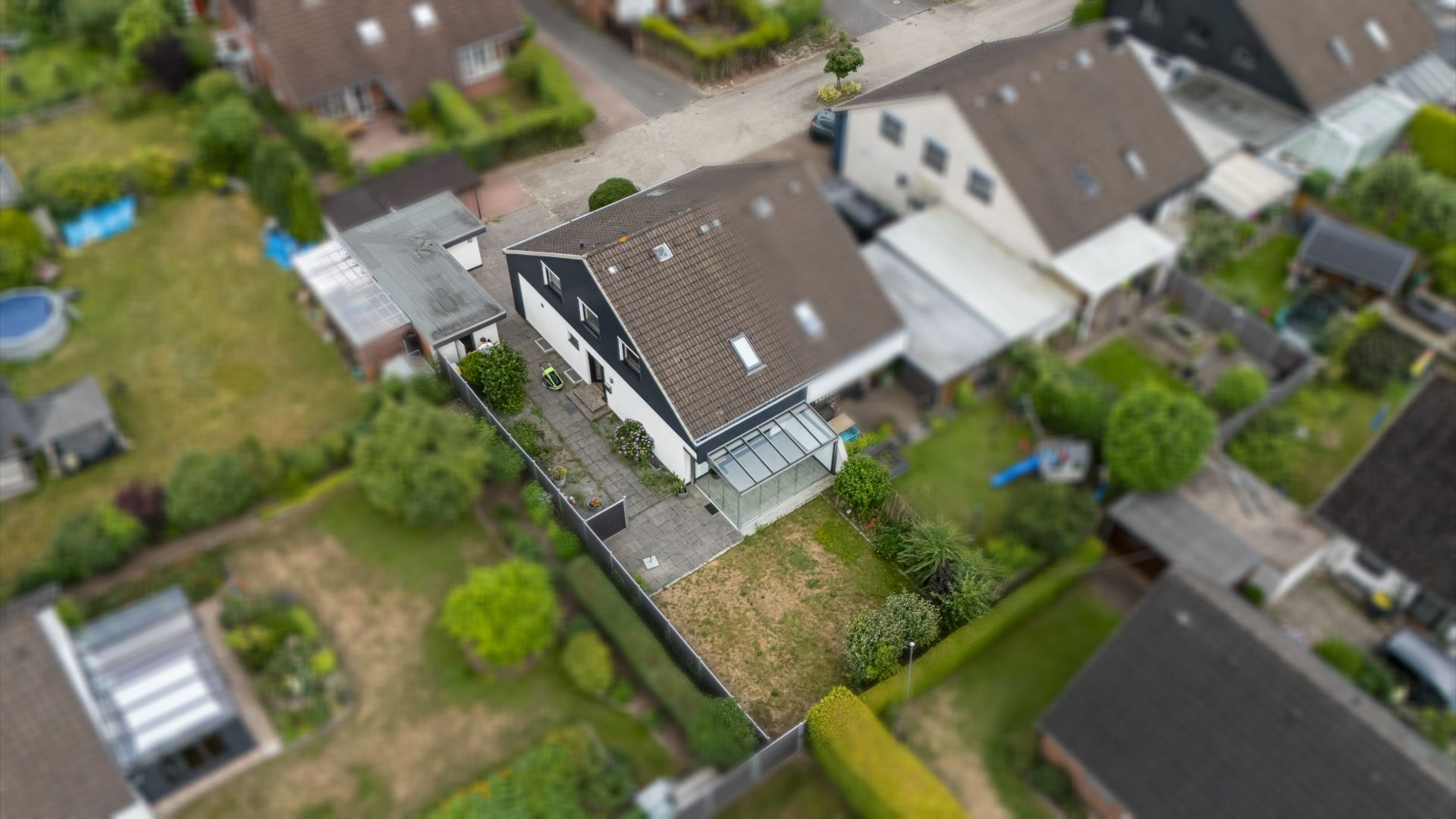 Luftbild eines Einfamilienhauses mit Garten und überdachter Terrasse.