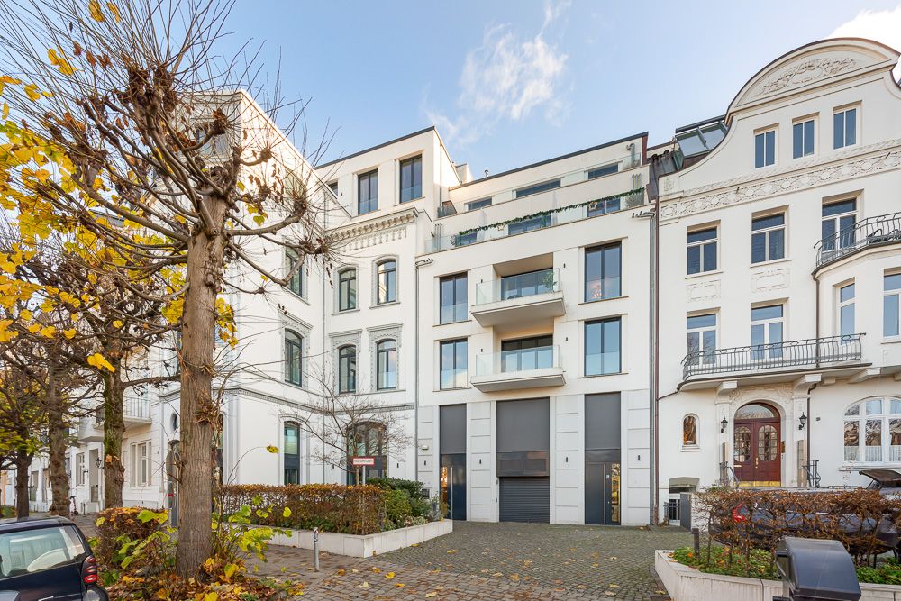 Moderne mehrstöckige Wohngebäude mit Balkonen und Bäumen davor.