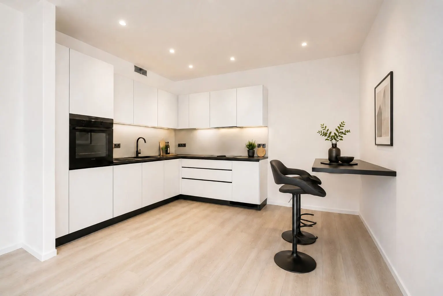 Moderne weiße Einbauküche mit Hockern an einer schmalen Theke und hellen Holzboden.