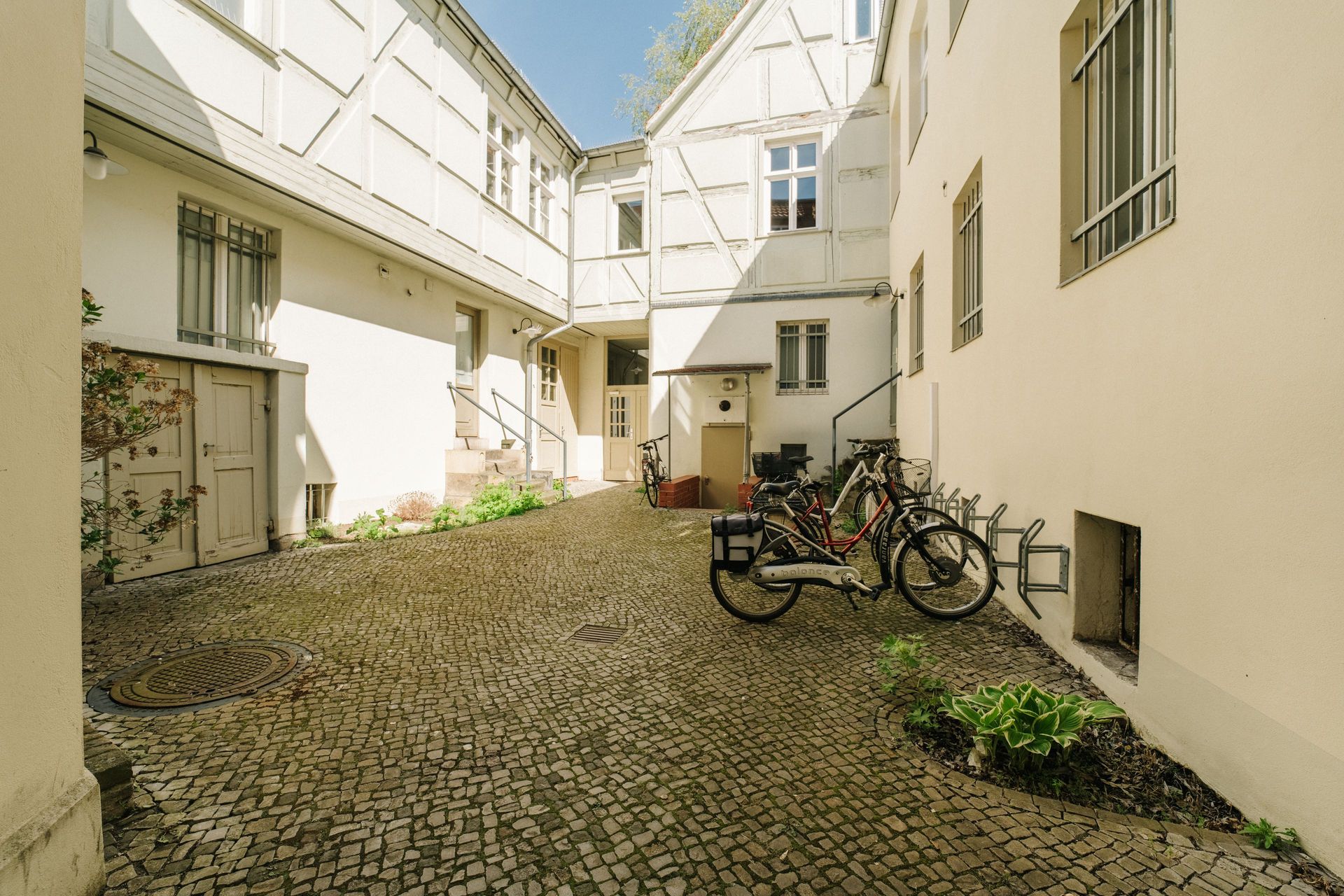 Gepflasterter Innenhof mit mehreren Fahrrädern an einem Fahrradständer neben Wohngebäuden.