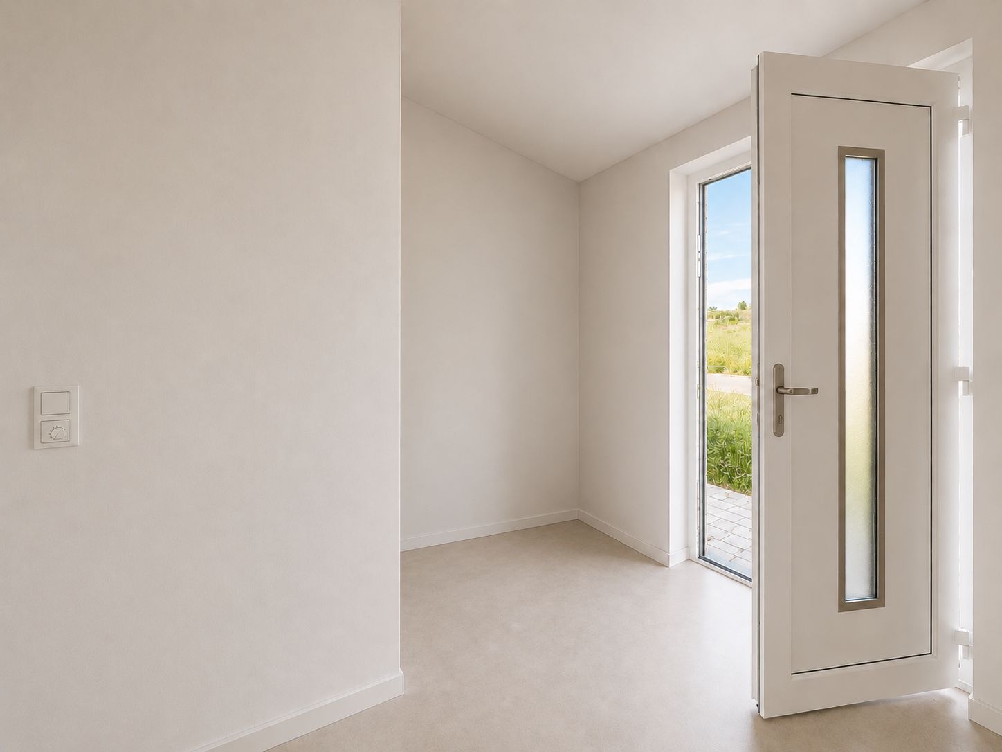 Heller Flur mit geöffneter weißer Haustür und Blick nach draußen auf eine Terrasse.