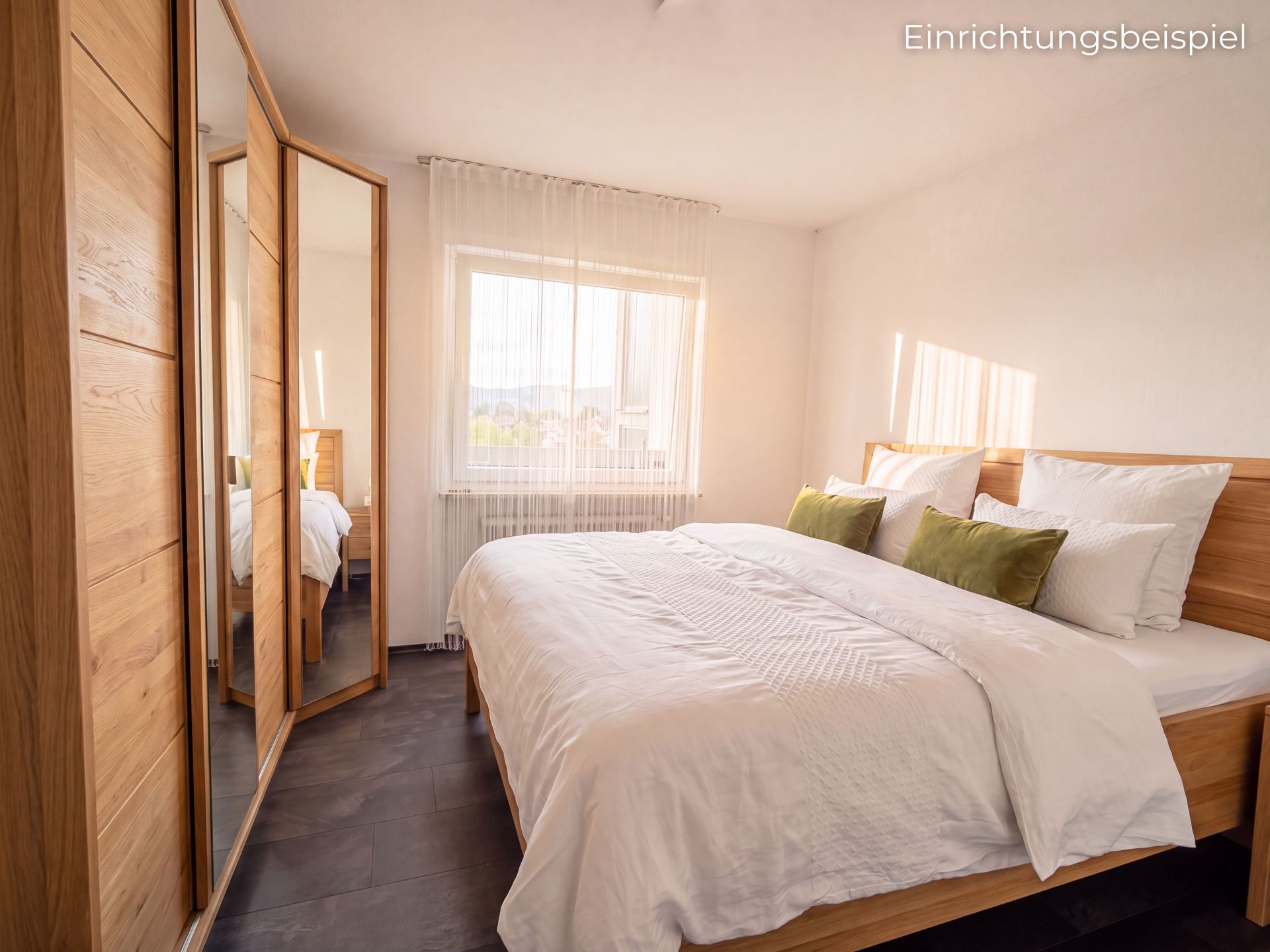 Helles Schlafzimmer mit Doppelbett, Holzbett, Spiegelkleiderschrank und Fenster mit Vorhang.