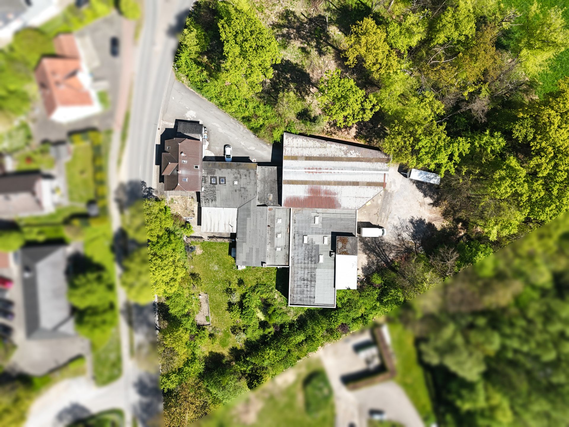 Luftaufnahme eines Wohnhauses mit Garten und angrenzendem Waldgebiet.
