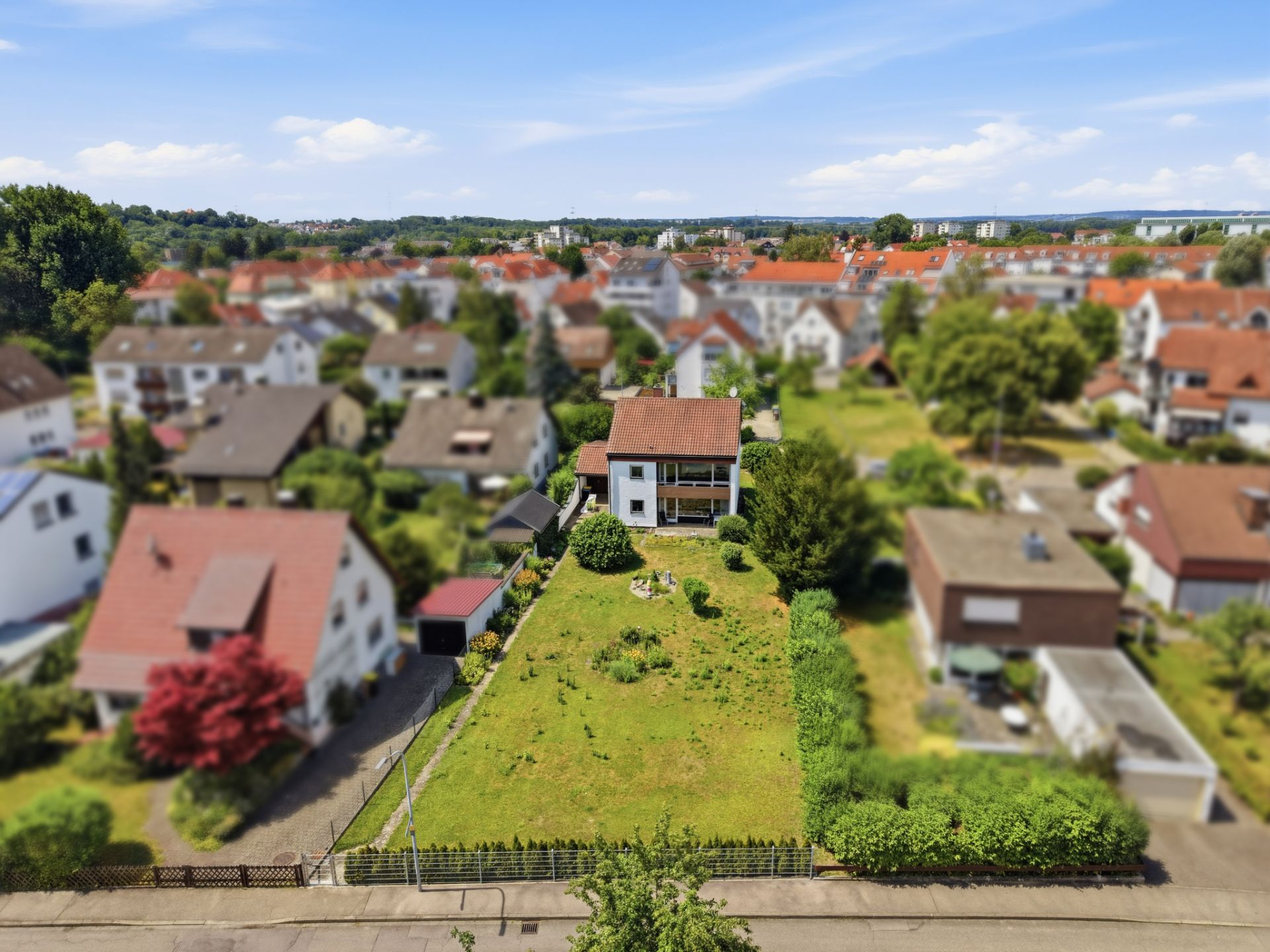 Luftaufnahme eines freistehenden Hauses mit großem Garten in einem Wohngebiet.