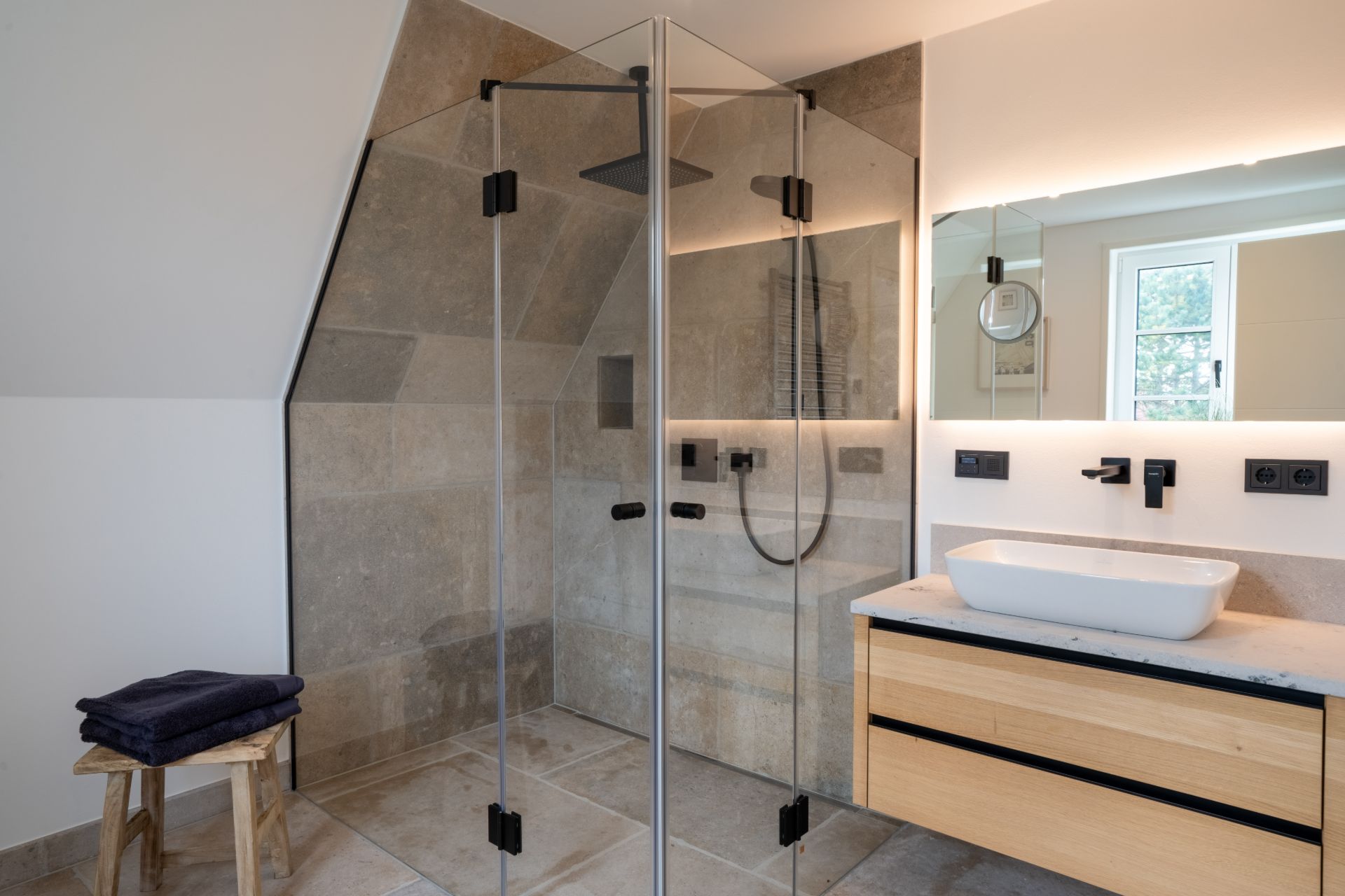 Modernes Badezimmer mit Glasdusche, Holzwaschtisch und Wandspiegel.