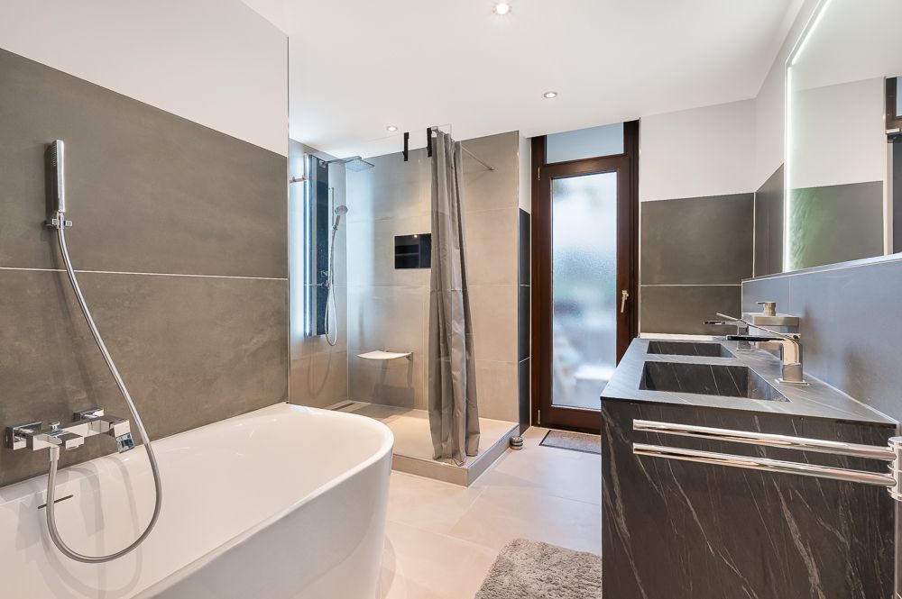 Modernes Badezimmer mit freistehender Badewanne, Dusche und Doppelwaschbecken.