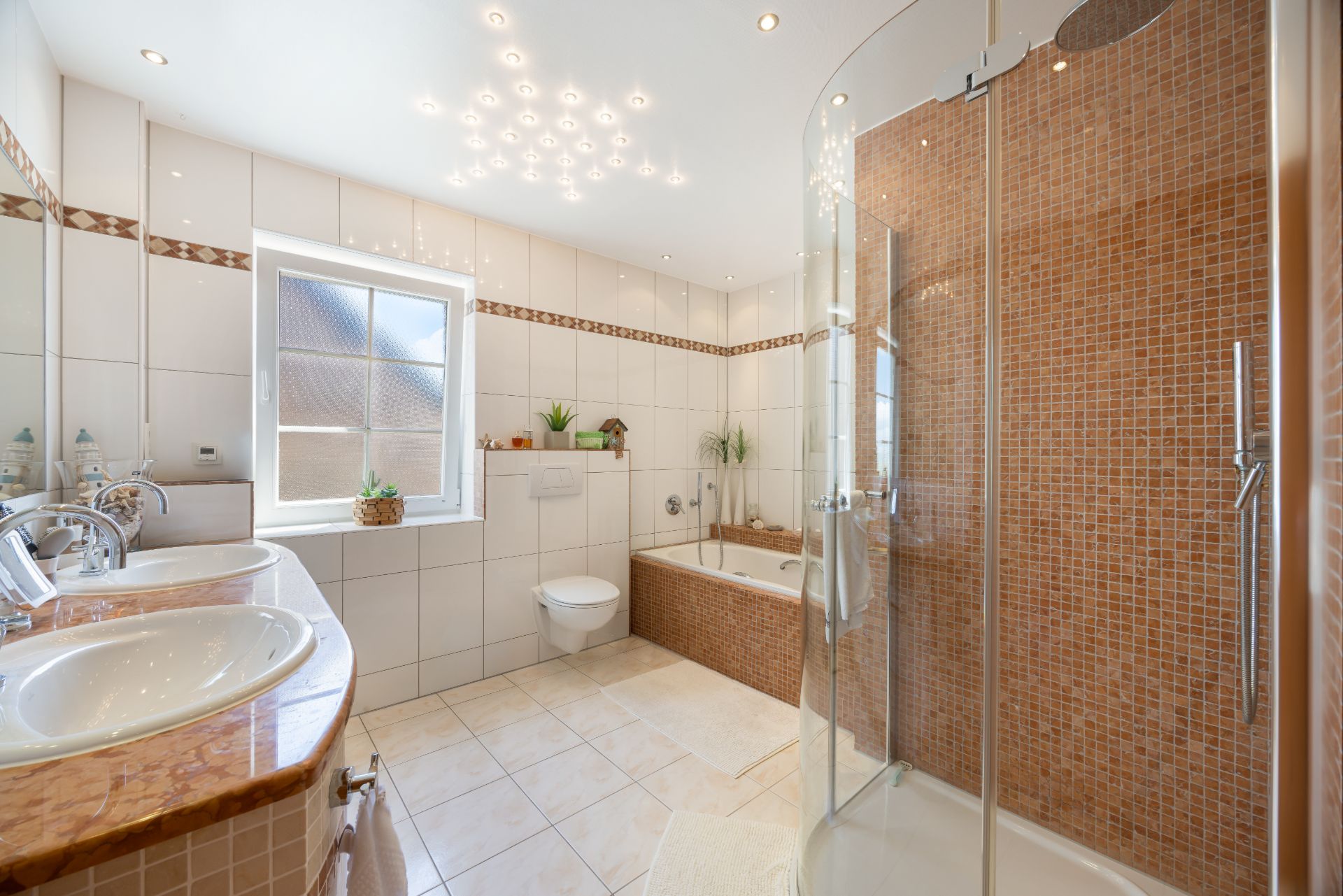 Modernes Badezimmer mit Doppelwaschbecken, Dusche, Badewanne, WC und Fenster.