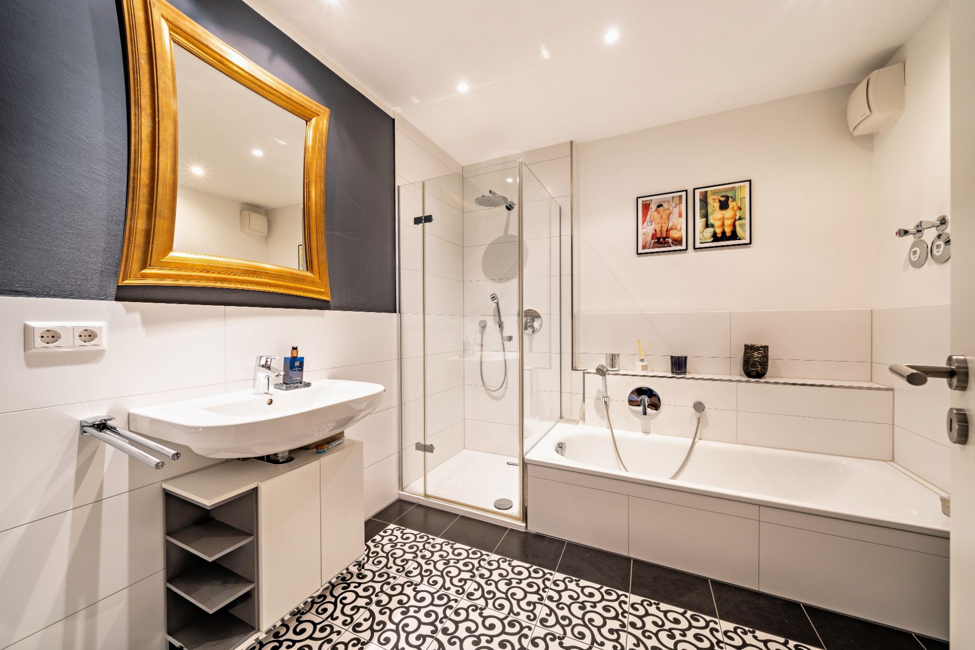 Modernes Badezimmer mit Dusche, Badewanne, Waschbecken, Spiegel und gemustertem Boden.