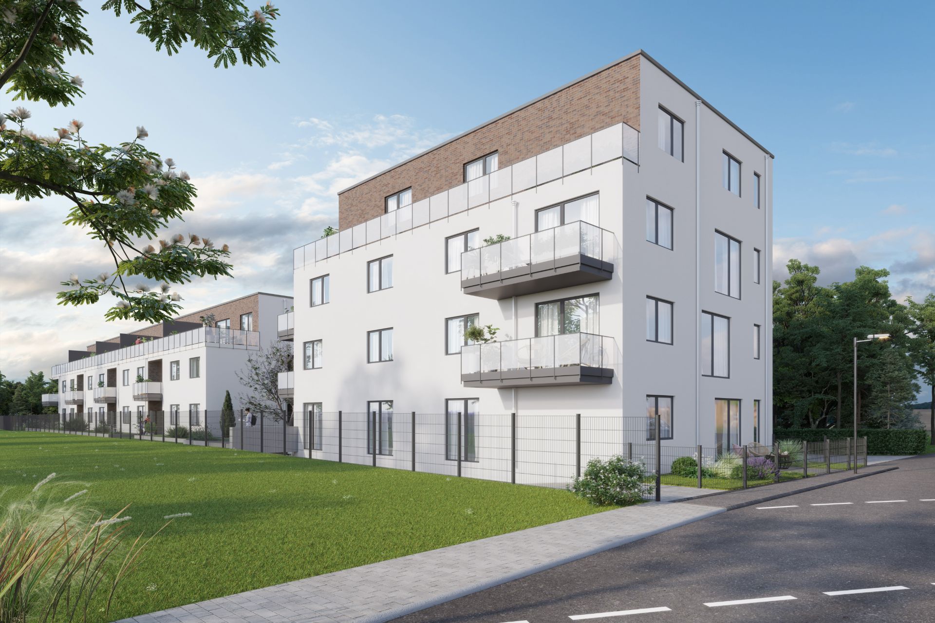 Modernes Wohngebäude mit mehreren Balkonen an einer Straße und angrenzender Grünfläche.
