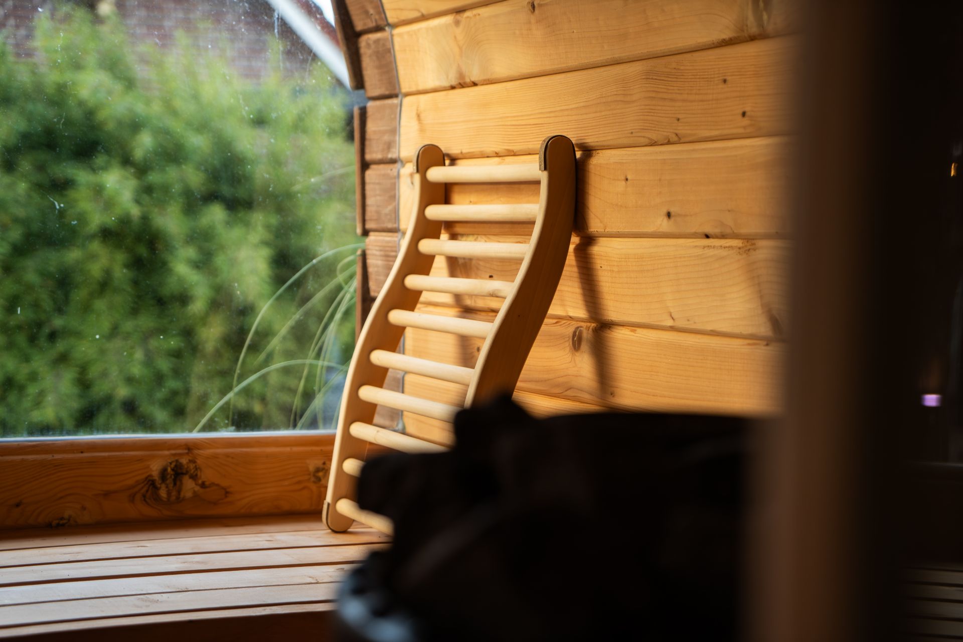 Holzliege an einem Fenster in einem Raum mit Holzverkleidung.