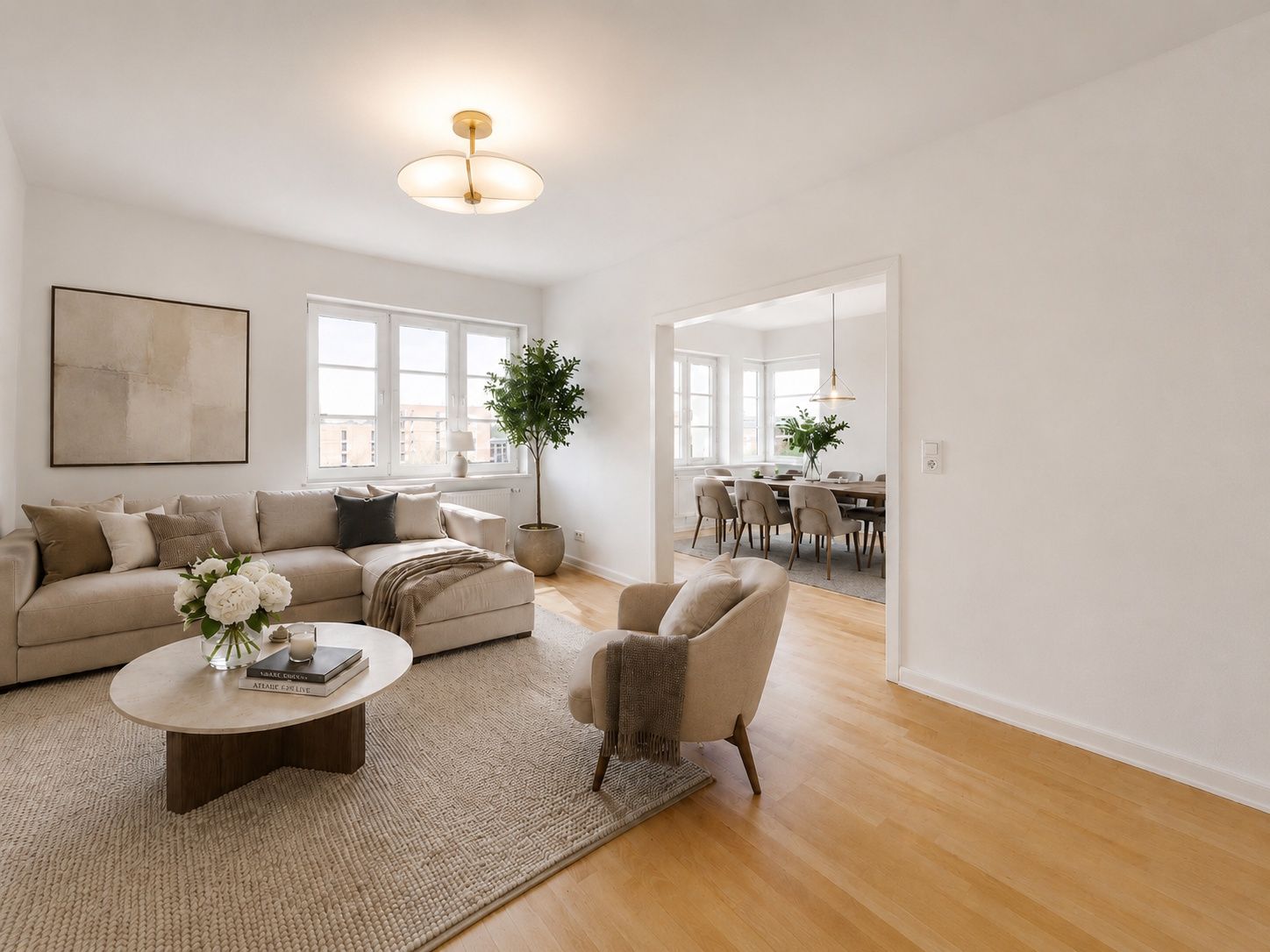 Helles Wohnzimmer mit Ecksofa, Sessel, Couchtisch und Blick in ein Esszimmer.