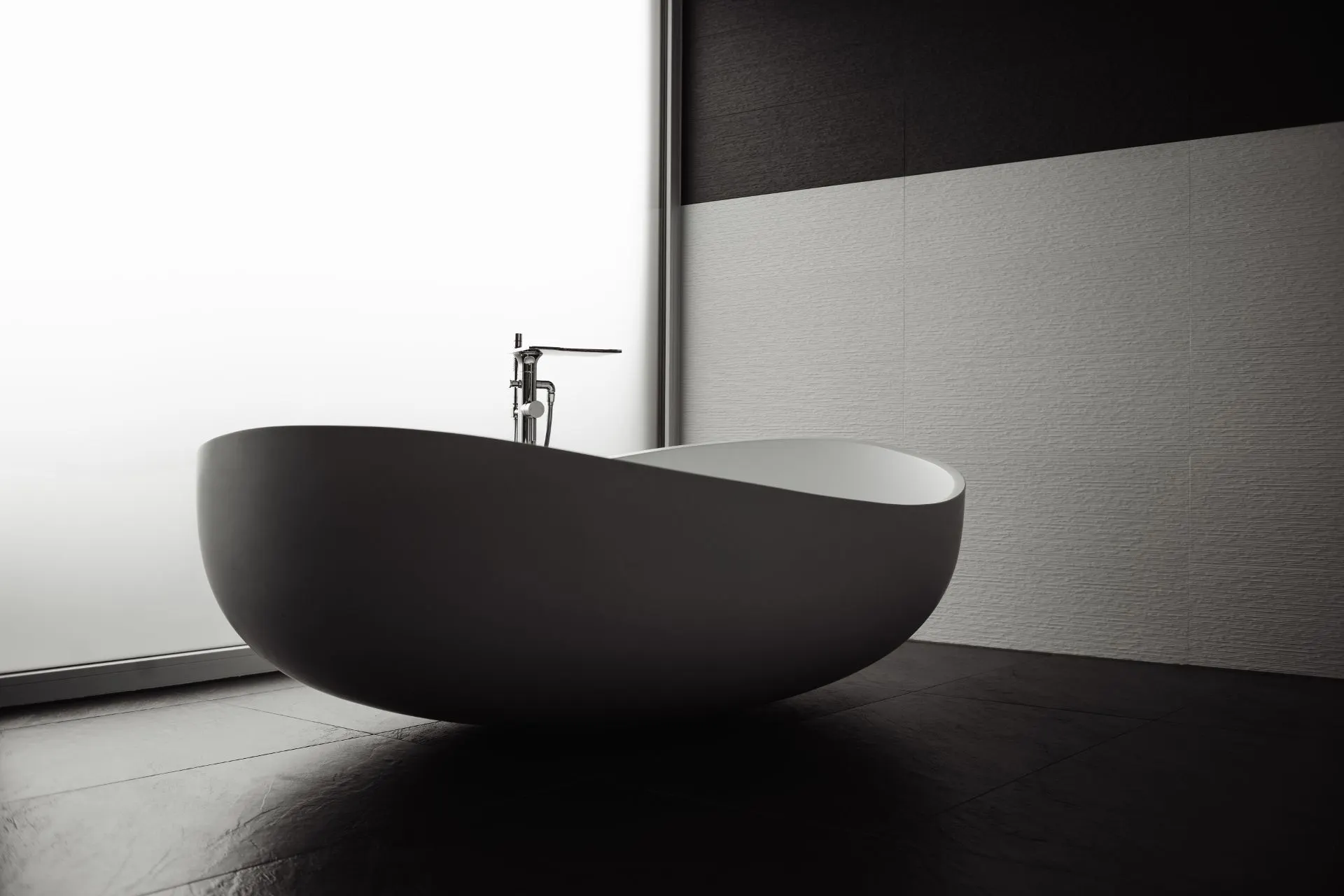 Freistehende Badewanne in modernem Badezimmer mit dunklem Boden und heller Wand.