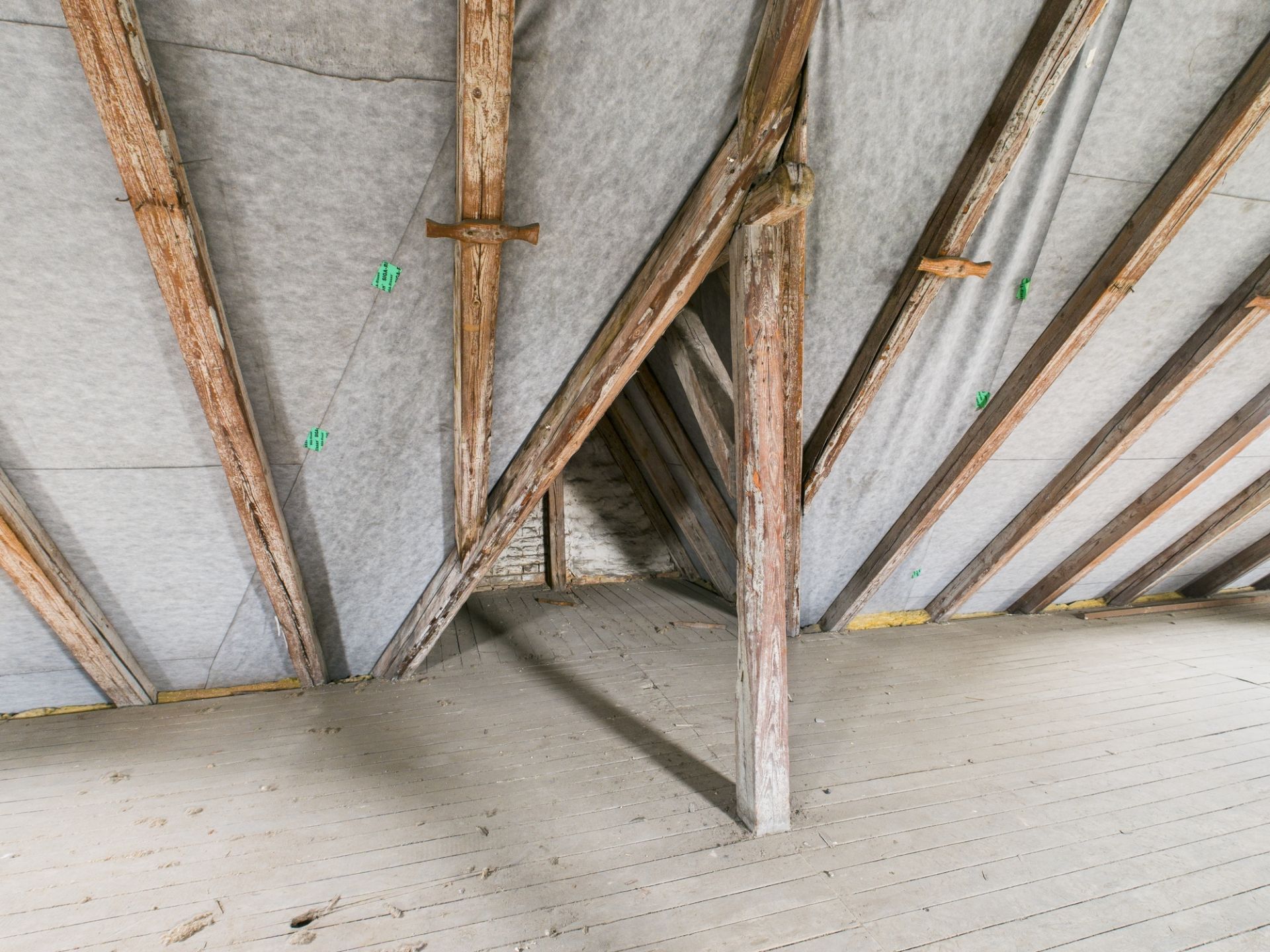 Dachboden mit sichtbaren Holzbalken und Holzfußboden.