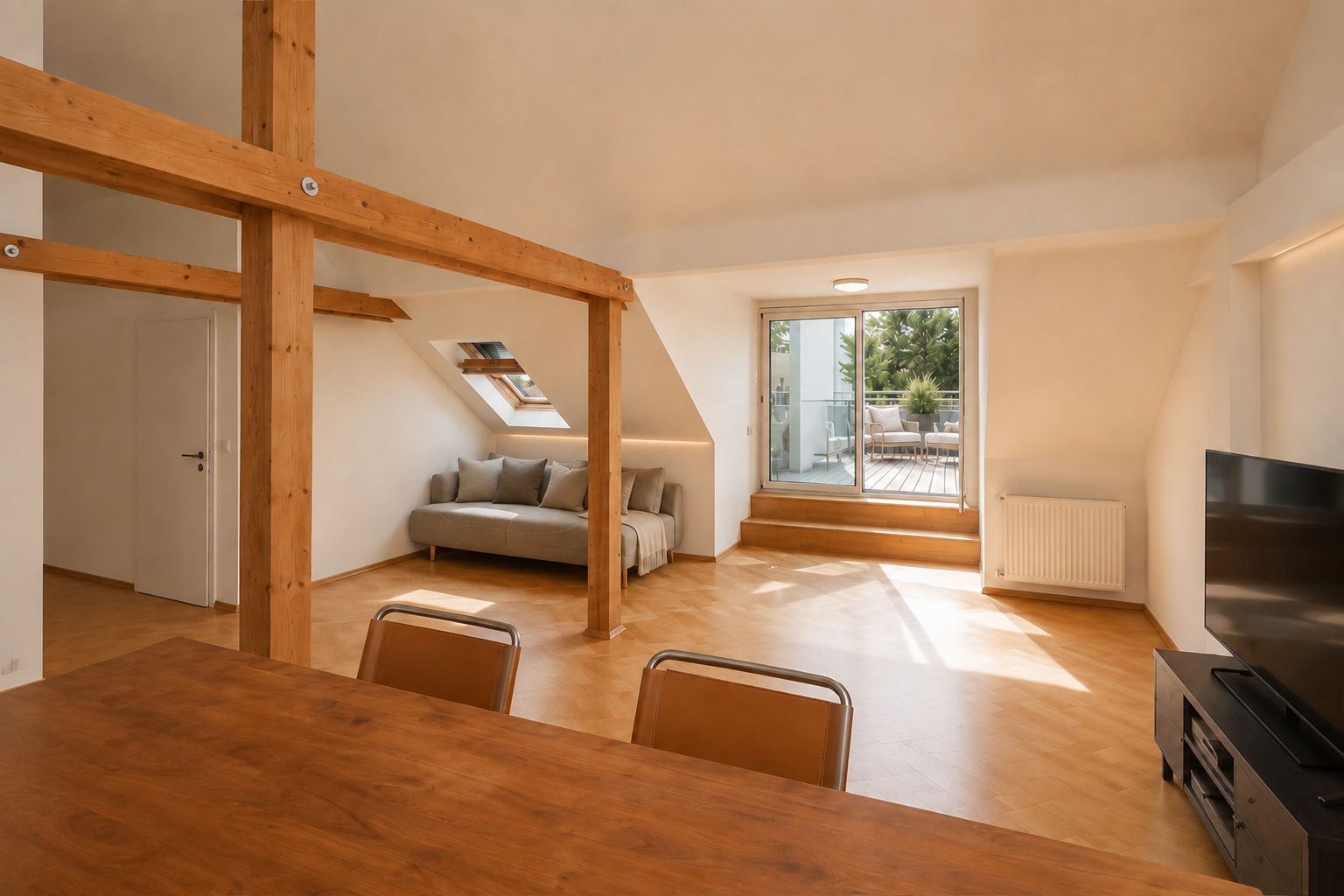 Helles Wohnzimmer mit Holzbalken, Sofa, Esstisch, Fernseher und Zugang zu einer Terrasse.