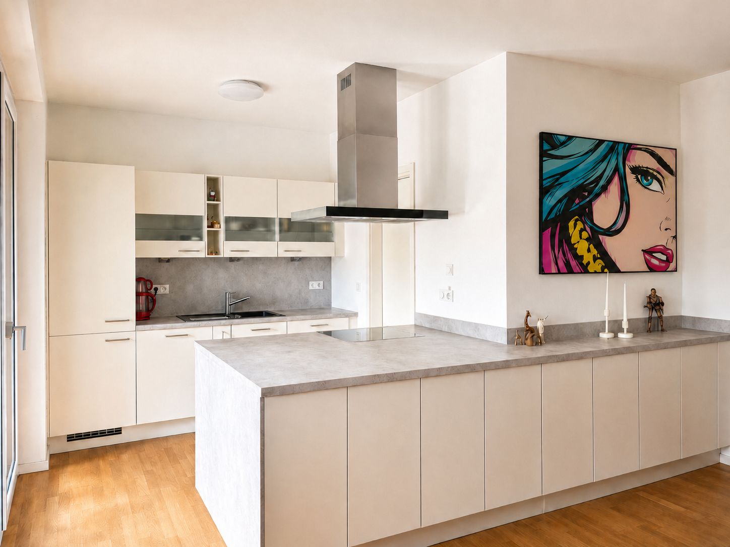 Moderne Einbauküche mit weißer Front, Holzfußboden und bunter Pop-Art an der Wand.