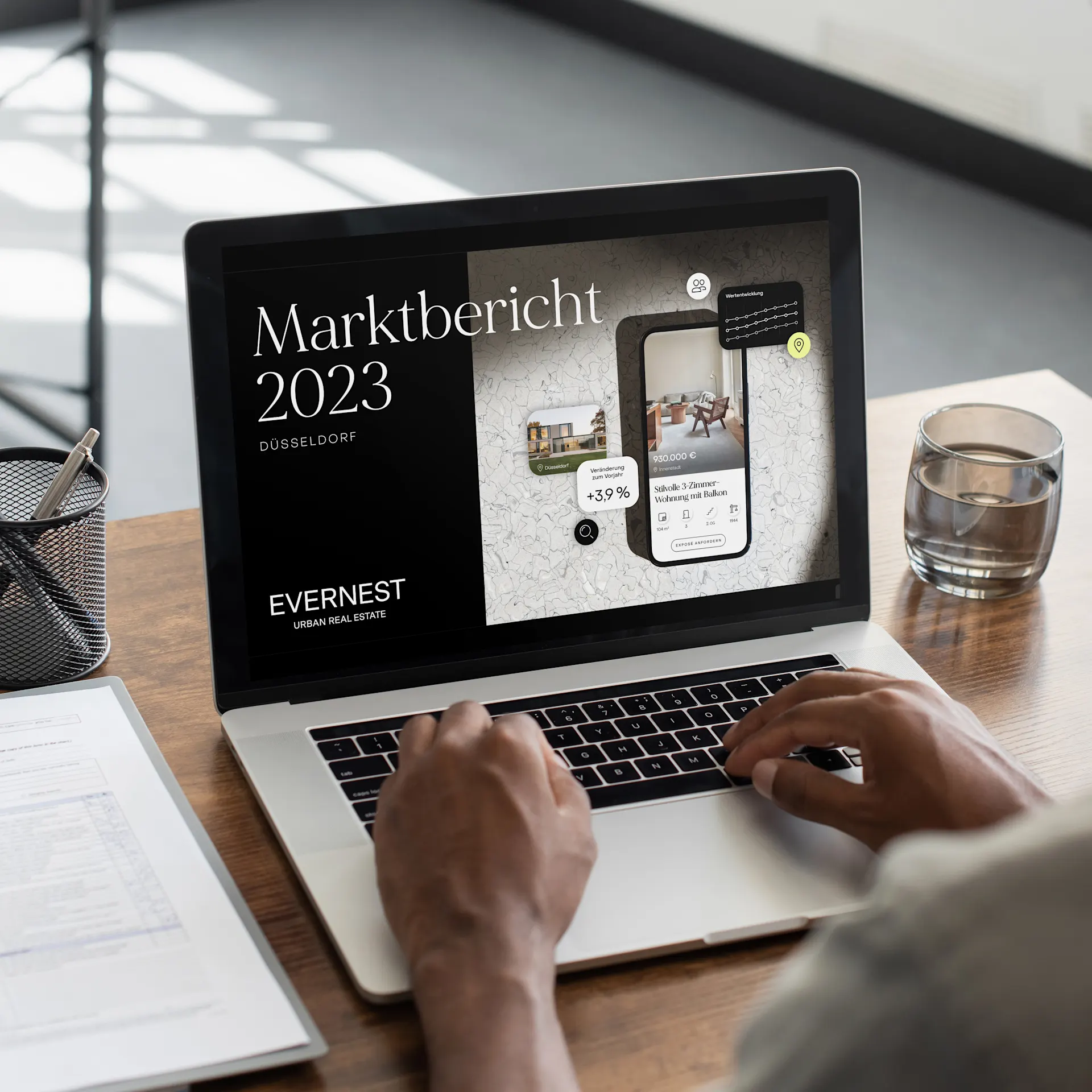 Person arbeitet am Laptop mit Immobilienmarktbericht Düsseldorf 2023 auf dem Bildschirm.