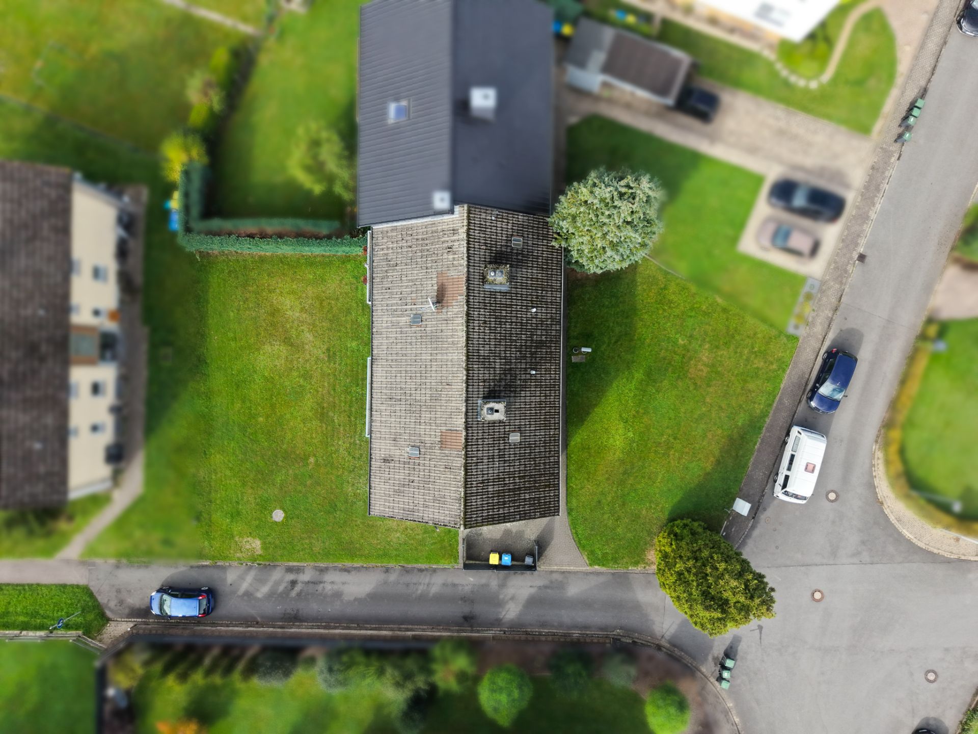 Luftaufnahme eines Wohnhauses mit Garten und angrenzenden Straßen.