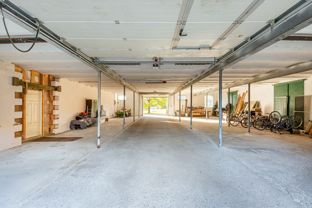 Große Garage mit mehreren Fahrrädern, Werkzeugen und Gegenständen an den Seiten.