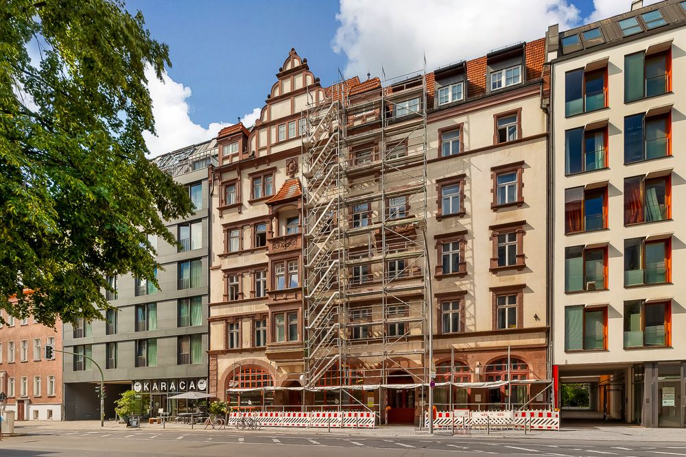 Mehrstöckiges Wohnhaus mit Baugerüst an der Fassade im Stadtzentrum.