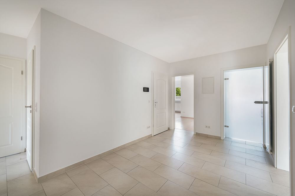 Heller Flur mit Fliesenboden und mehreren Türen in einer Wohnung.