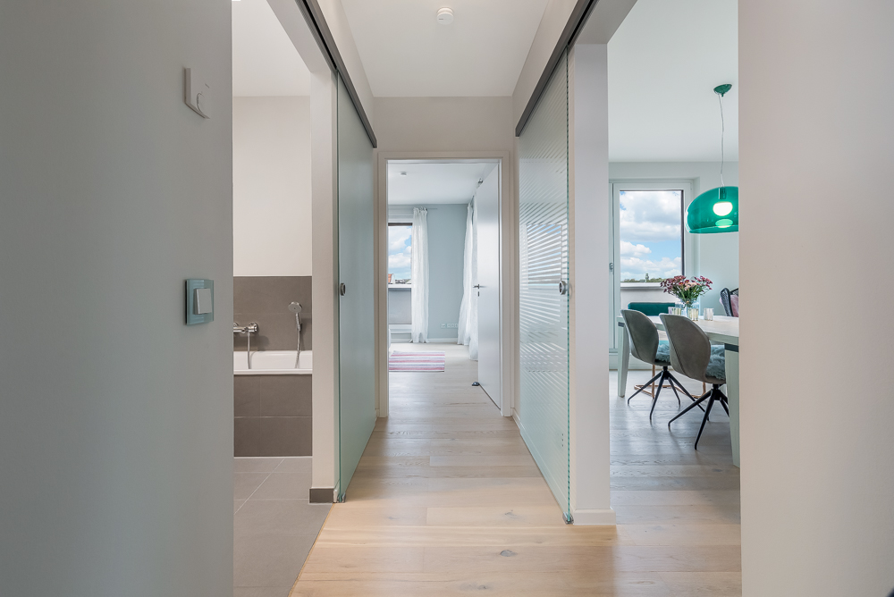 Heller Flur mit Zugang zum Badezimmer links und Esszimmer rechts, Blick ins Wohnzimmer.