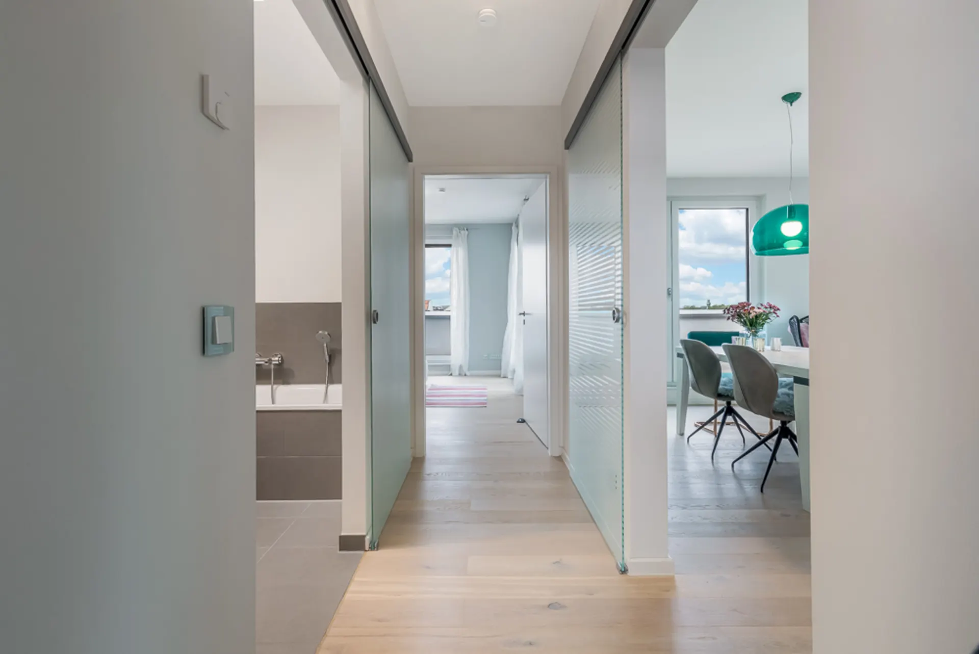 Heller Flur mit Zugang zum Badezimmer links und Esszimmer rechts, Blick ins Wohnzimmer.
