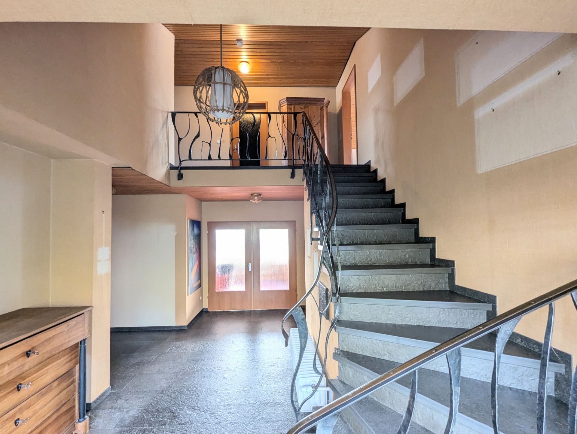 Eingangsbereich mit Treppe, Doppeltür und Geländer im Wohnhaus.