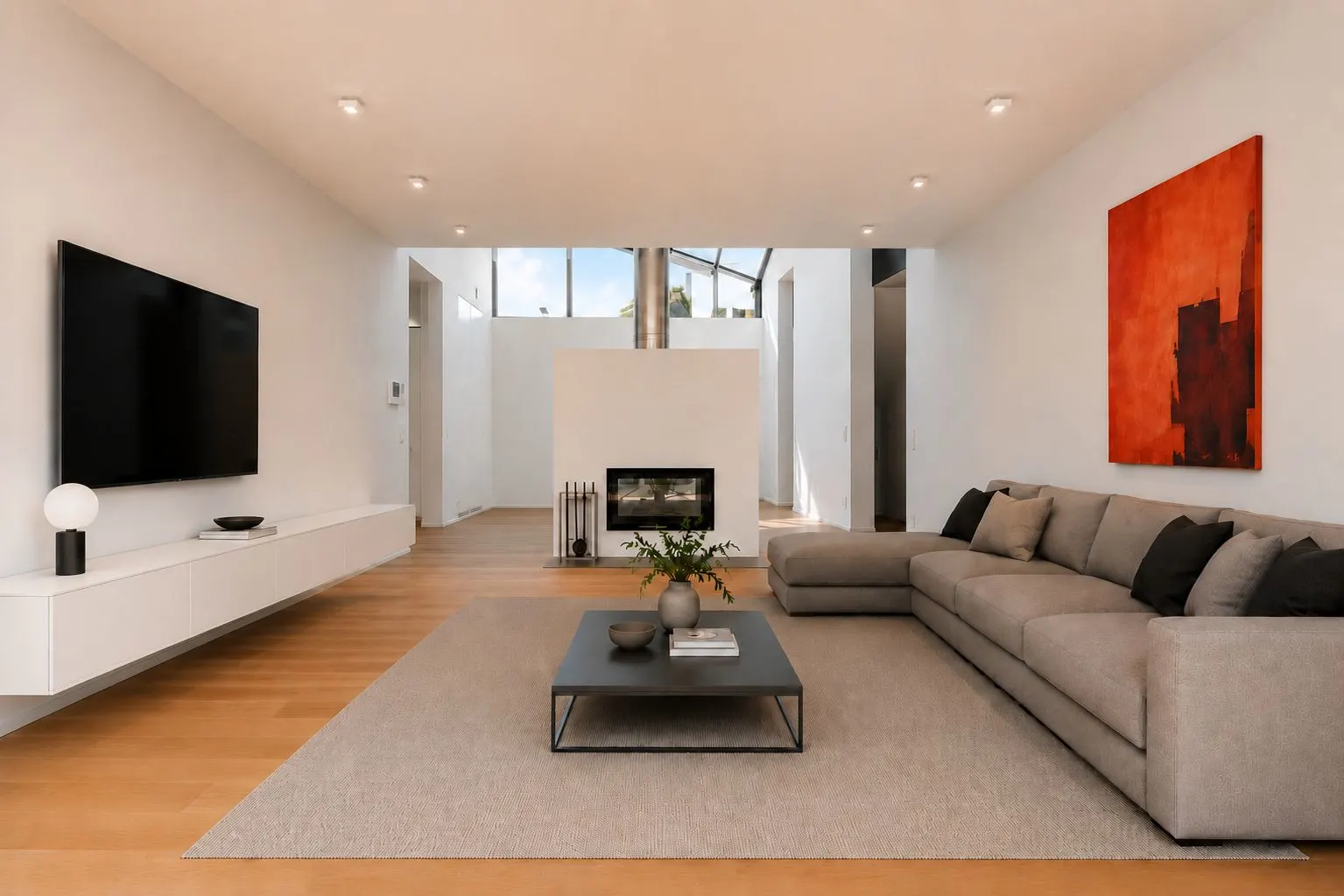 Modernes Wohnzimmer mit großem Sofa, Kamin, Wandbild und Fernseher.