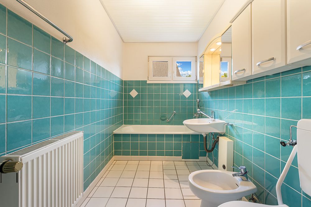 Badezimmer mit türkisfarbenen Fliesen, Badewanne, Waschbecken, Bidet und Toilette.