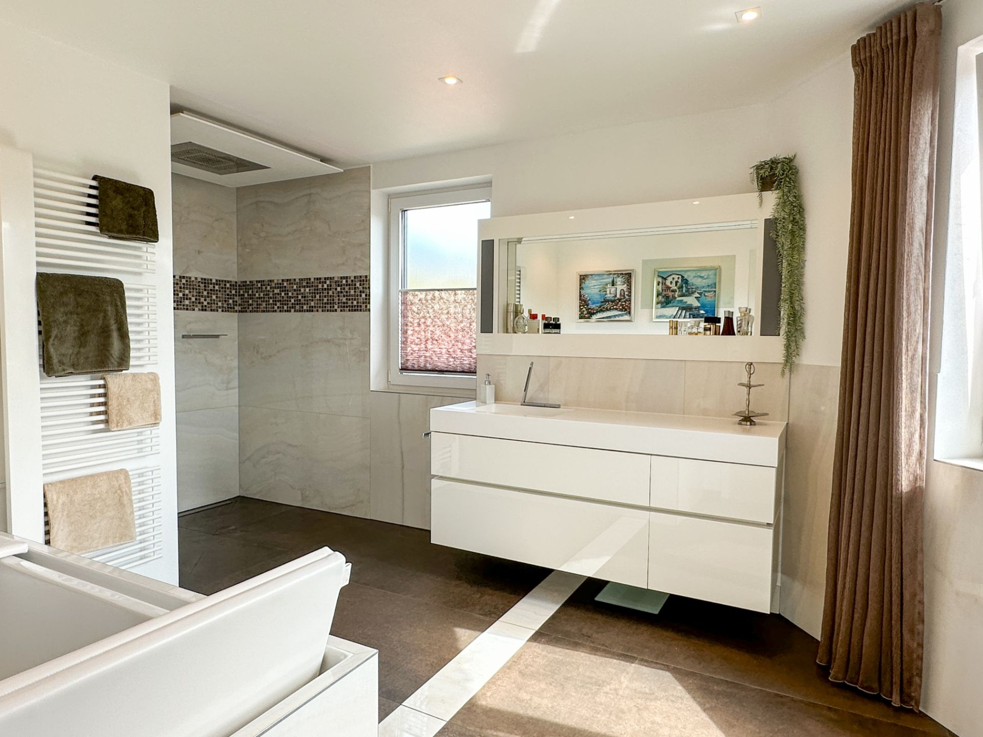 Modernes Badezimmer mit weißem Waschbecken, Dusche, Handtuchheizung und zwei Fenstern.