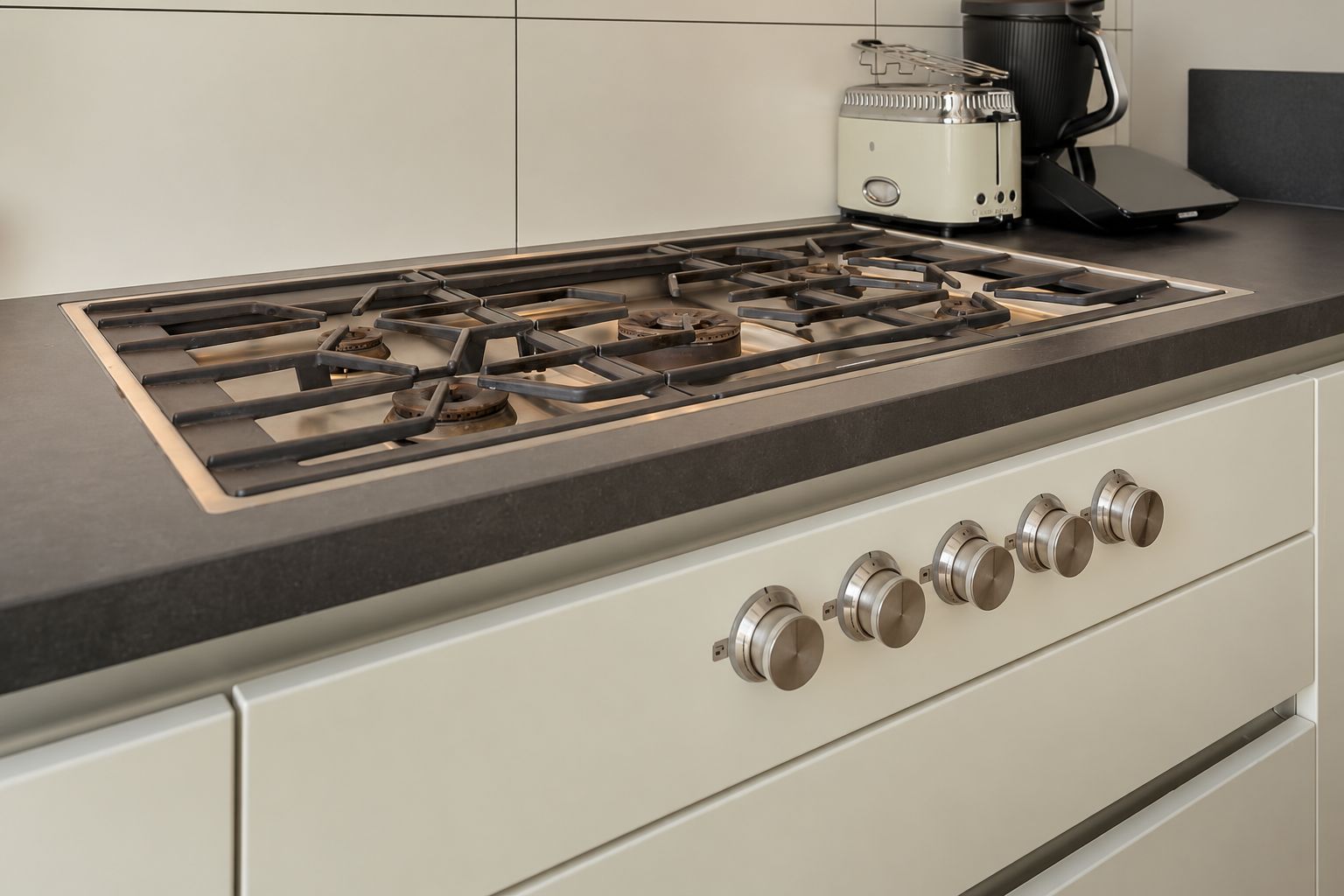 Gaskochfeld mit fünf Drehknöpfen auf einer modernen Küchenarbeitsplatte.