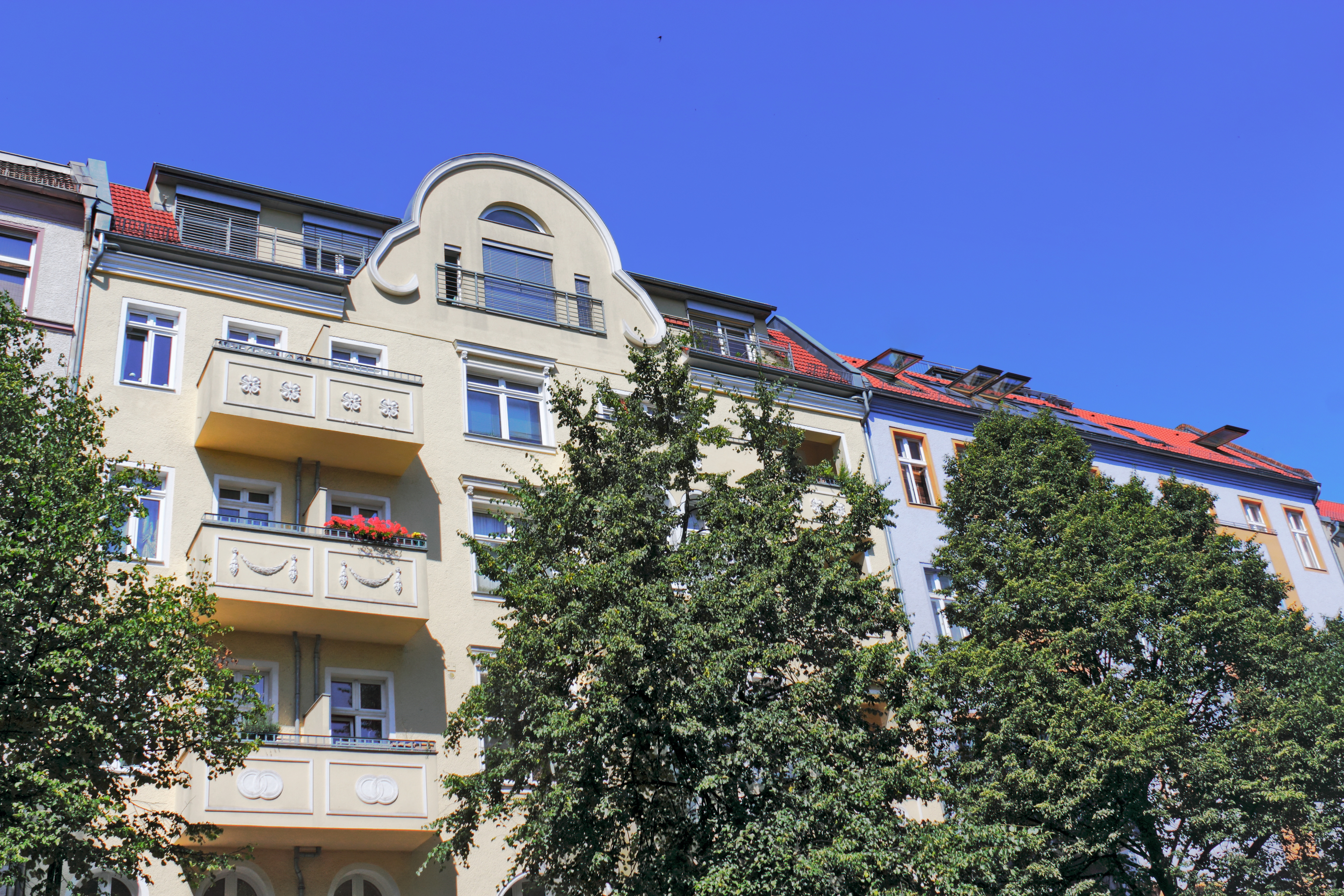 Steinerne Brücke über einen Kanal, umgeben von Bäumen und Gebäuden im Hintergrund.