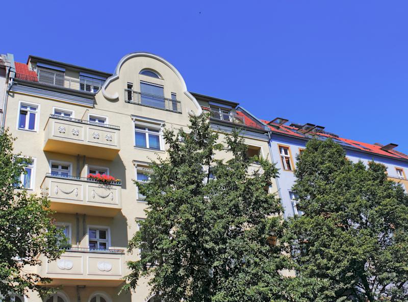 Steinerne Brücke über einen Kanal, umgeben von Bäumen und Gebäuden im Hintergrund.