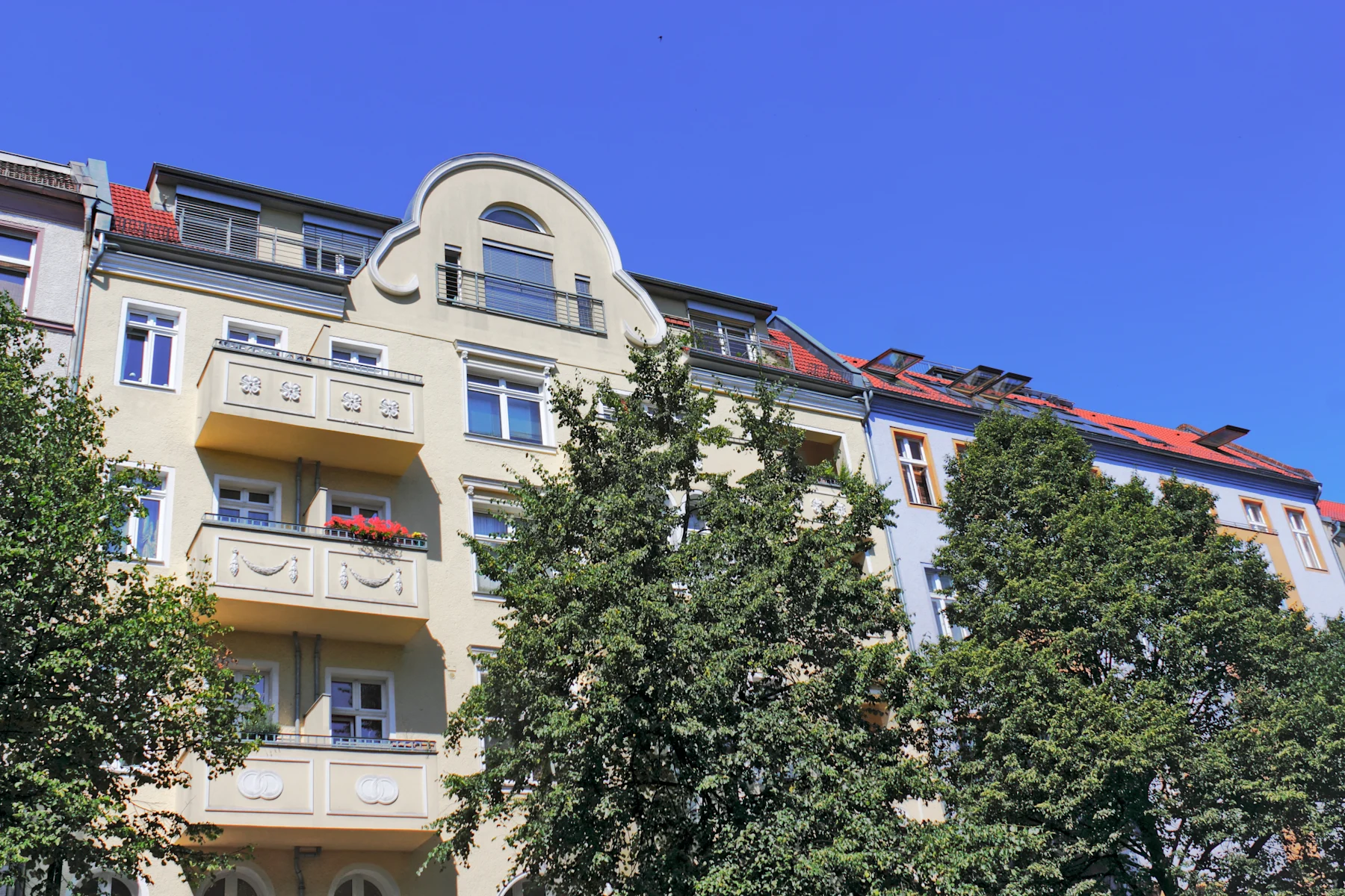 Steinerne Brücke über einen Kanal, umgeben von Bäumen und Gebäuden im Hintergrund.