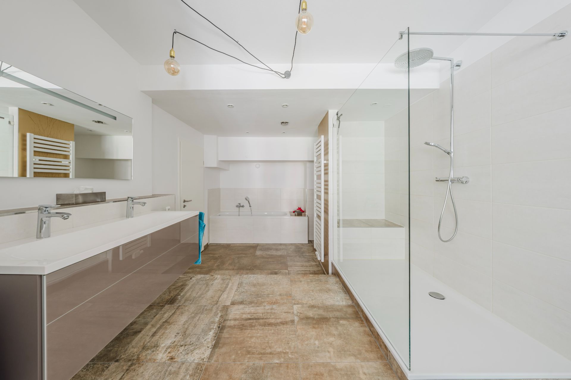 Modernes Badezimmer mit Doppelwaschbecken, großer Dusche und Badewanne.