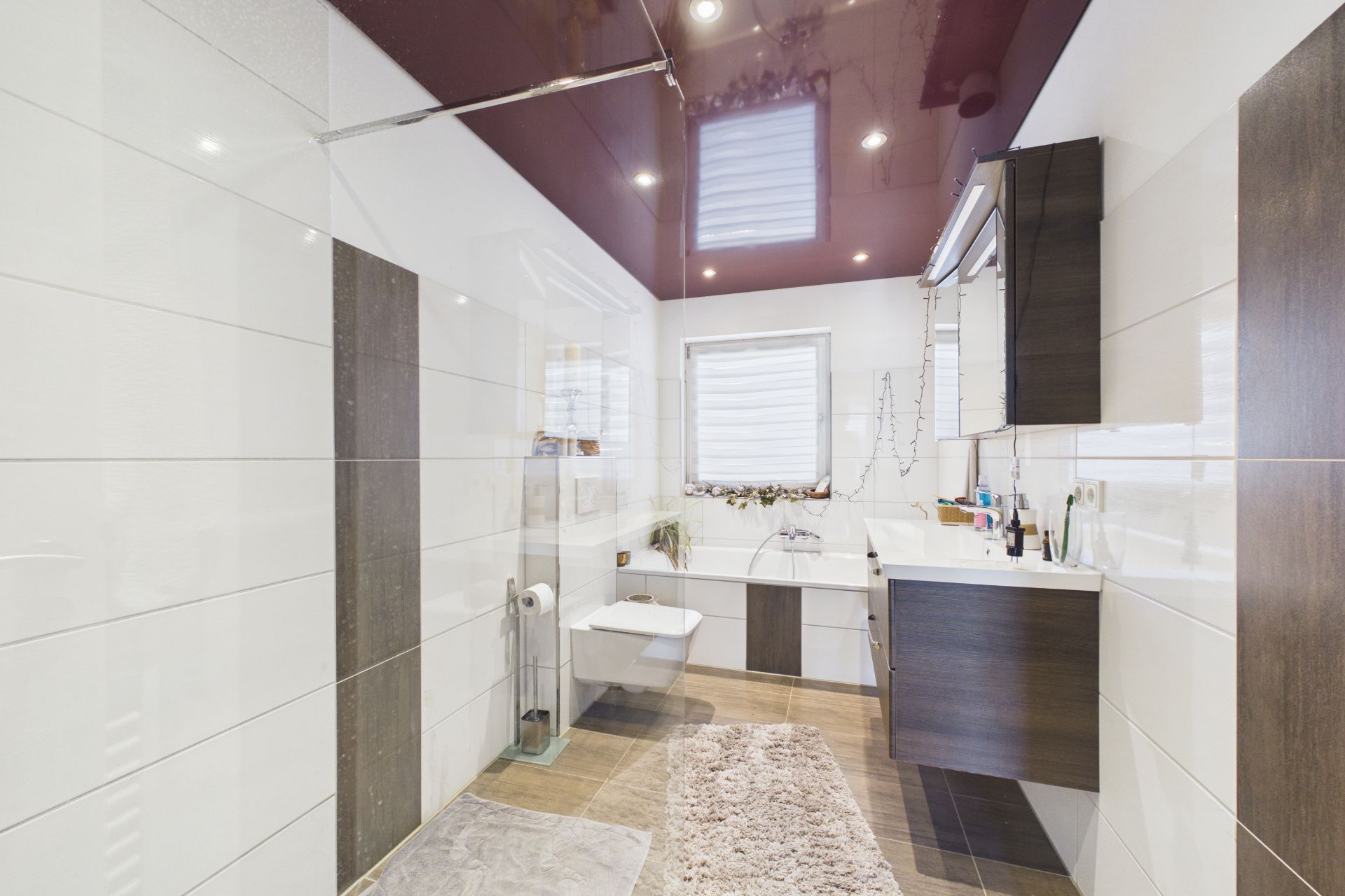 Modernes Badezimmer mit Badewanne, Waschbecken, WC und großem Fenster.