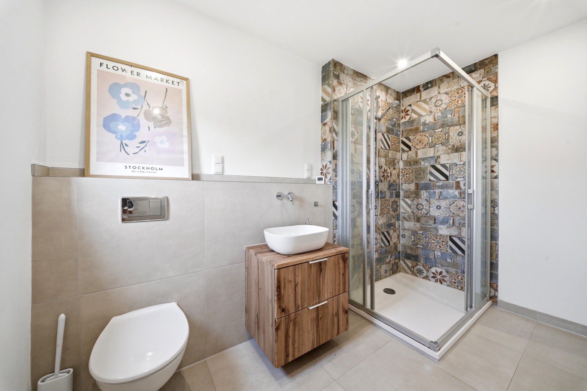 Modernes Badezimmer mit Dusche, WC, Holzwaschtisch und Blumenbild an der Wand.