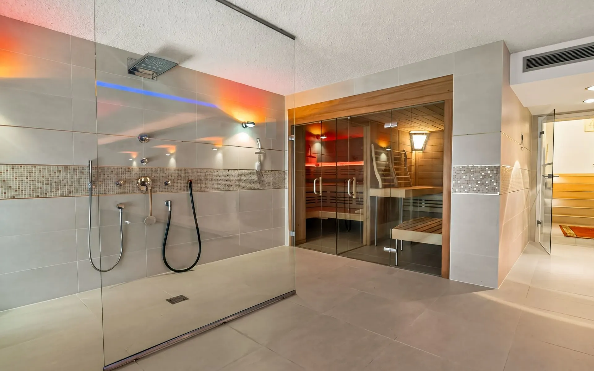 Modernes Badezimmer mit großer Dusche und angeschlossener Sauna aus Holz.