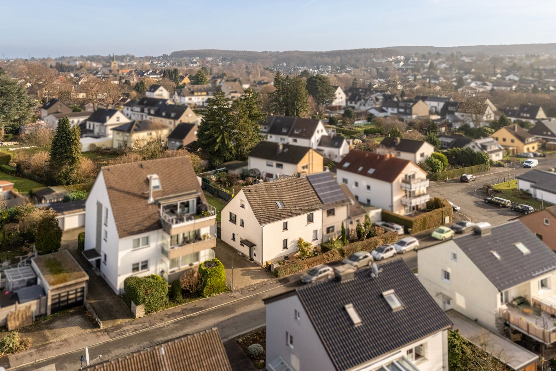 Vogelperspektive auf ein Wohnviertel mit mehreren Einfamilienhäusern und Bäumen.