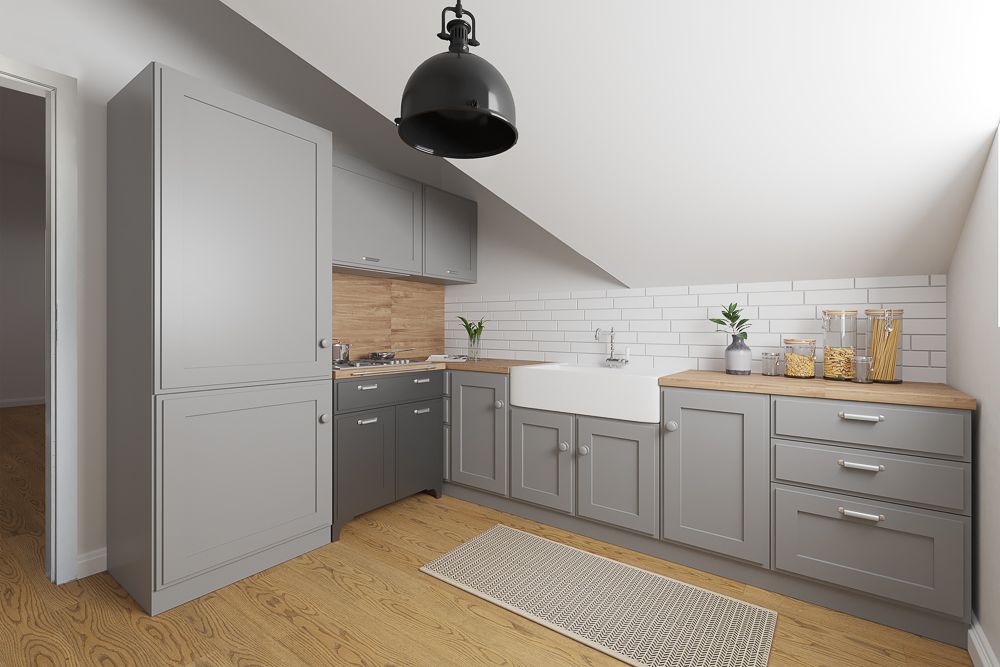 Moderne Küche mit grauen Schränken, Holzboden und einem großen weißen Spülbecken.