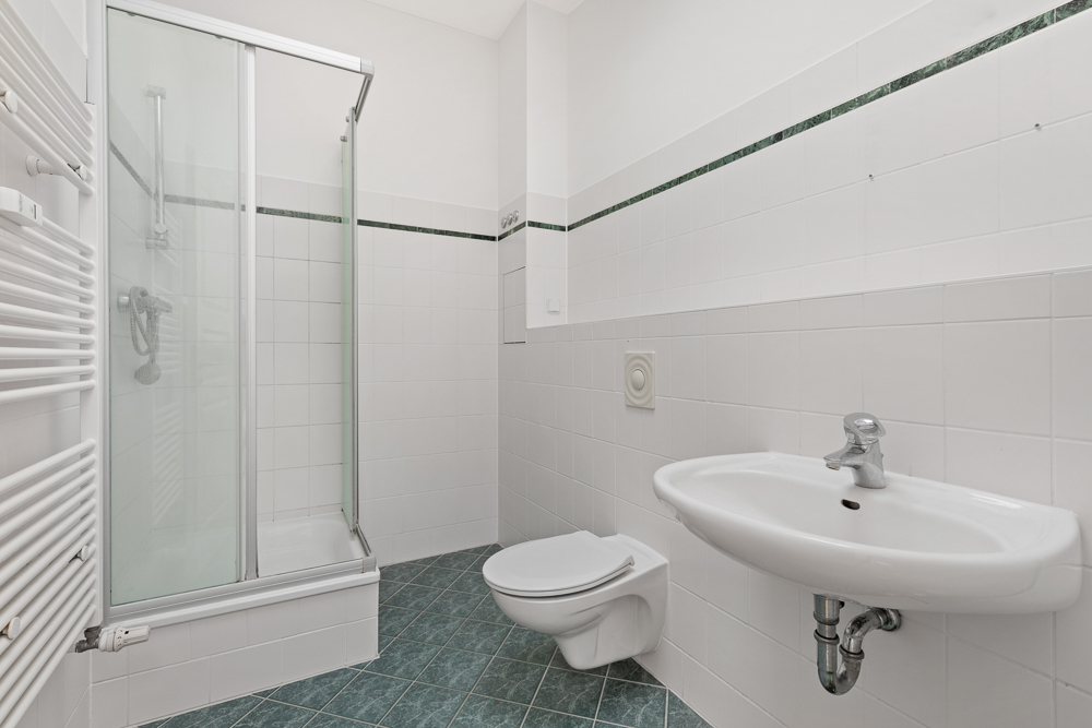Modernes Badezimmer mit Dusche, Wandwaschbecken und wandhängender Toilette.