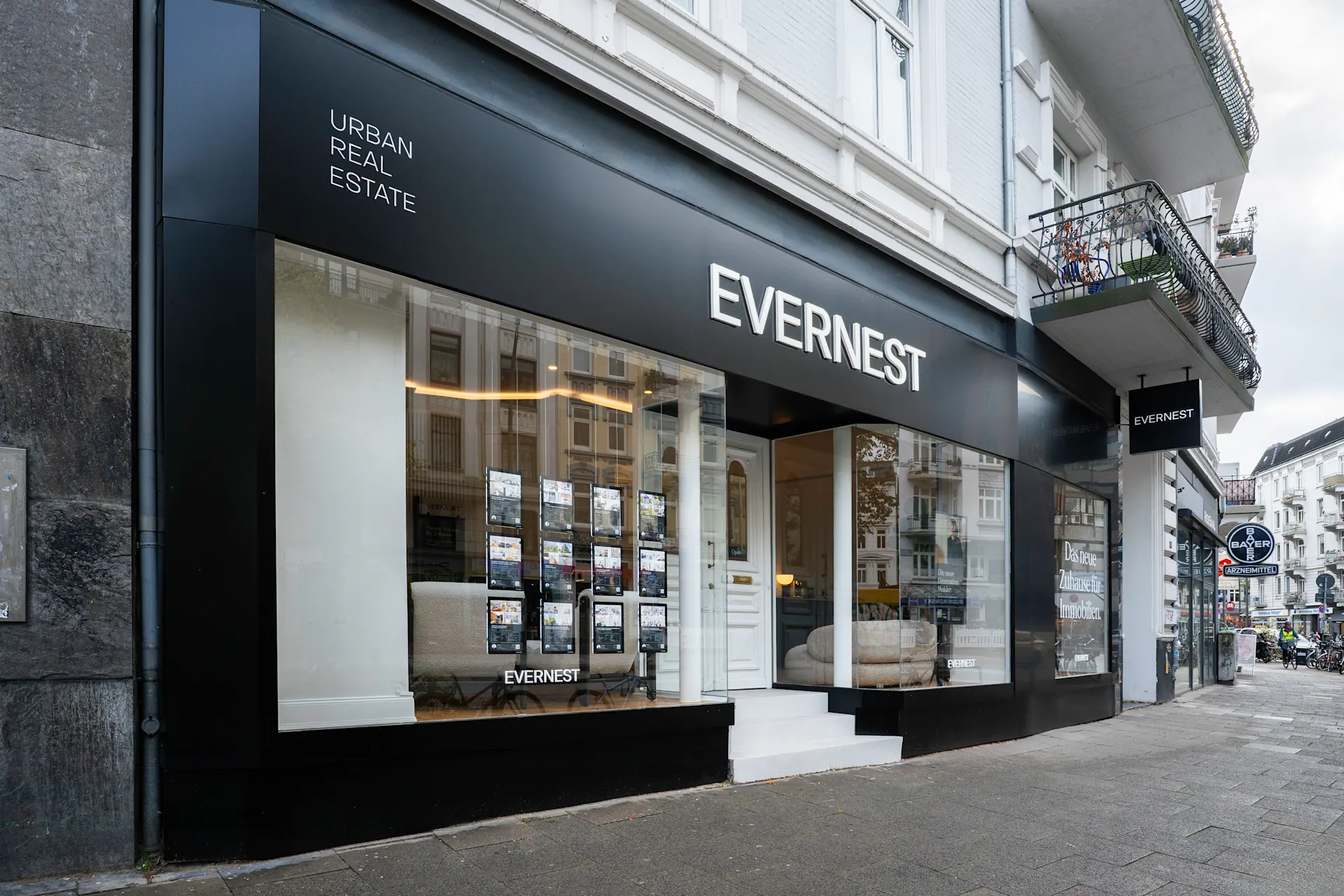 Schaufenster eines Immobilienbüros mit der Aufschrift 'EVERNEST' an einer Straßenecke.